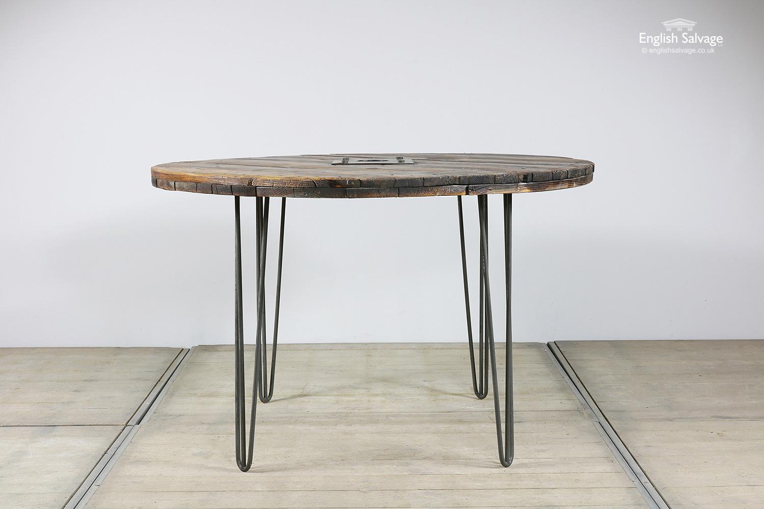 Reclaimed large vintage pine spool which has been repurposed into a circular table top with Mid Century metal legs. Splits, old nails and dings in the table top, as expected with past use.