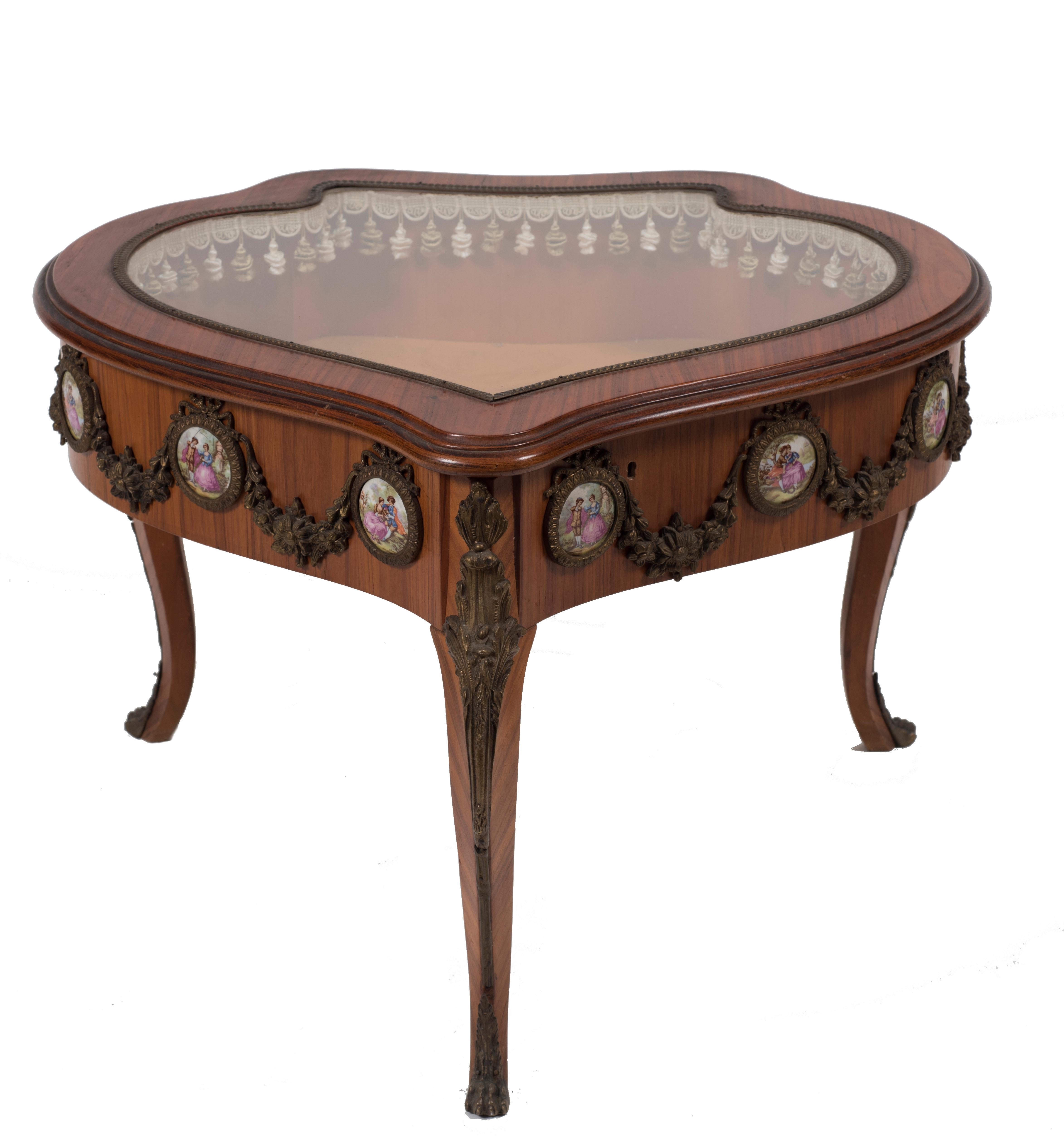 A wonderful vintage table, a piece of original furniture realized at the beginning of the 19th century by French manufacture.

The little heart-shaped showcase-table is decorated with bronze and porcelain medallions painted with genre scenes
