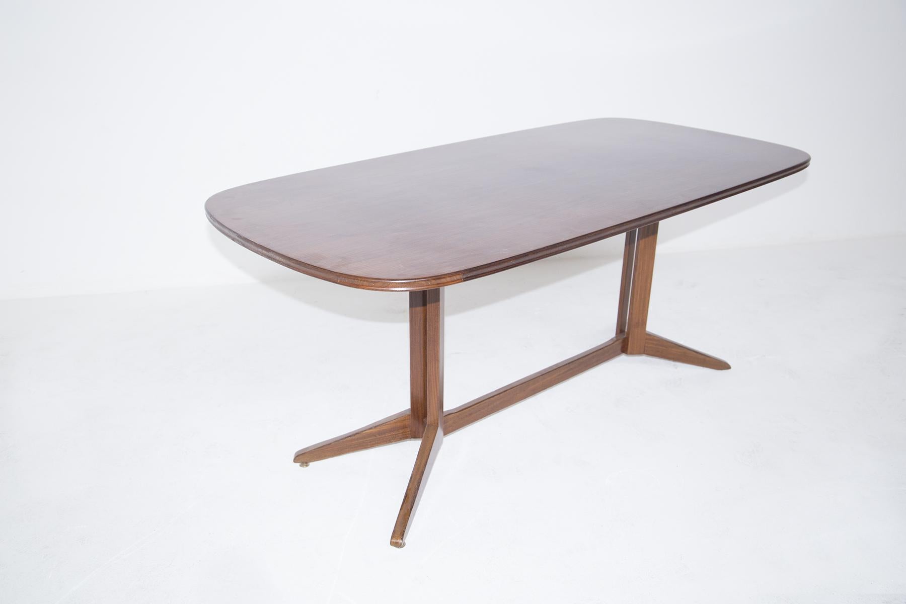 The vintage wooden table attributed to the designer Franco Albini. It has been made by fine Italian manufacturer Poggi in the 1950s. The table has an oval shape and has a base formed by two V-shaped feet, which connect to two square wooden