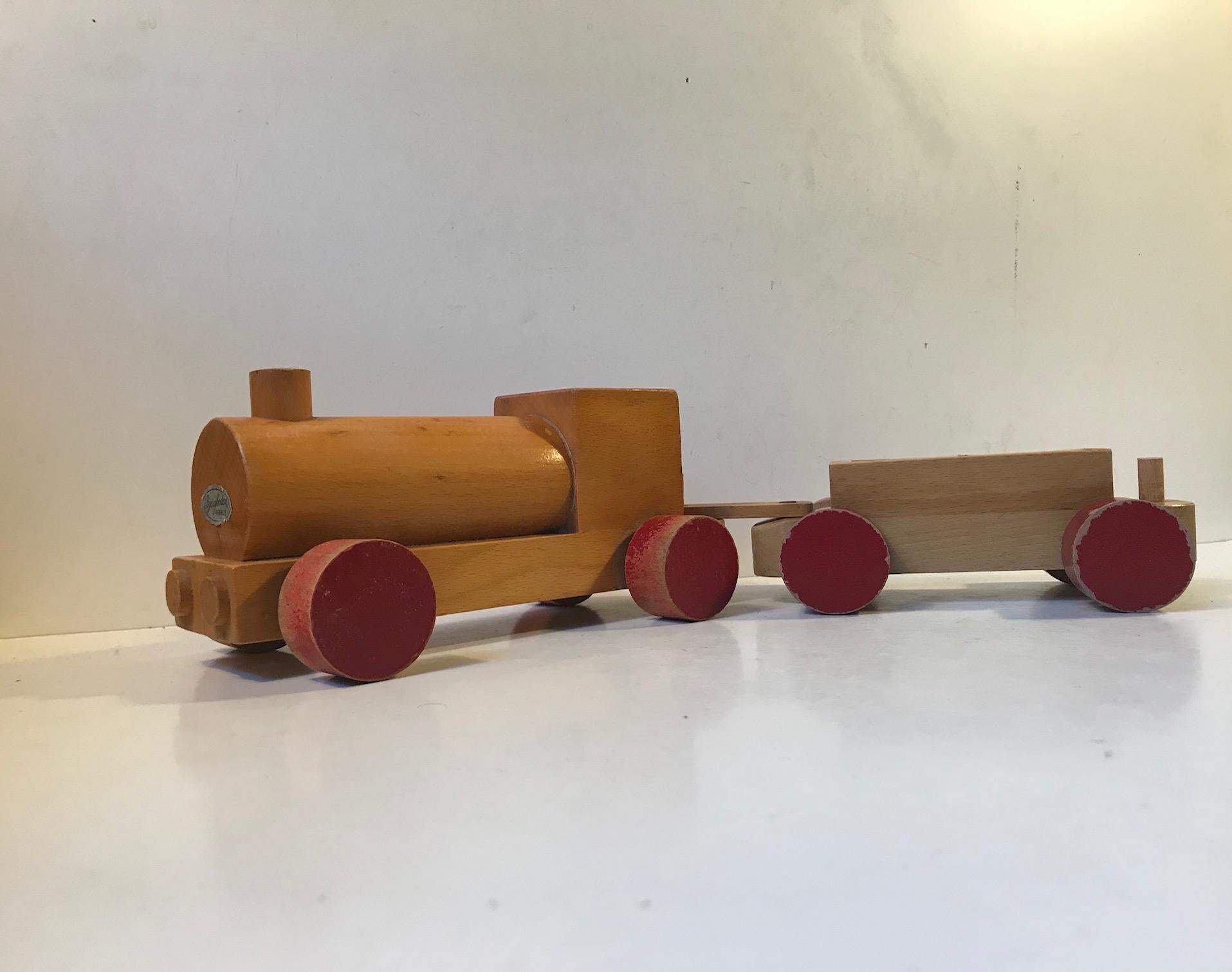 Vintage train or locomotive set made from partially lacquered and painted beechwood. This item surely has been loved and played with for decades and it show in the most charming way. It was designed by Kay Bojesen and manufactured in his own