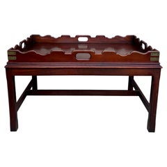 Mesa de centro con tablero de madera de estilo vintage, con bordes festoneados y detalles de latón