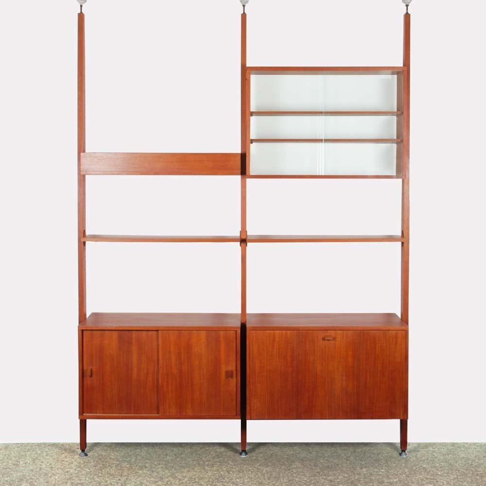 This vintage wooden wall unit dates from the 1960s. It can be used as a room divider. Shelves and pedestals are height-adjustable. It is fixed by a pressure system suitable for ceiling heights ranging from 240 to 270 cm. This storage unit can be