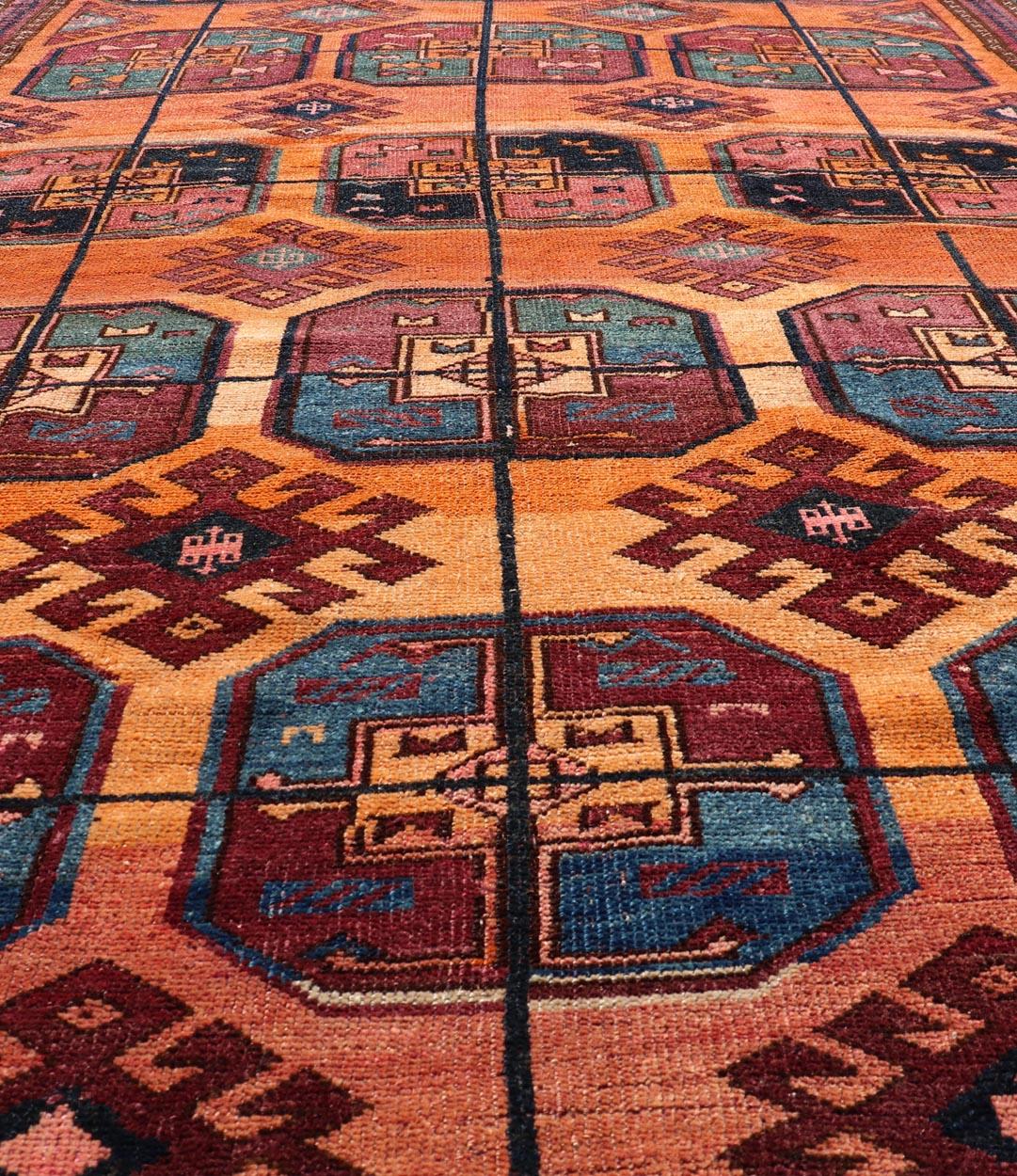Measures: 5'0 x 8'10 
Vintage Wool Ersari Rug in Wool with Gul Design in Orange, Blue, and Brown. Keivan Woven Arts; rug EMB-9543-13058, country of origin / type: Turkestan / Ersari, circa 1930s.

This Turkomen Ersari rug has been hand-knotted in