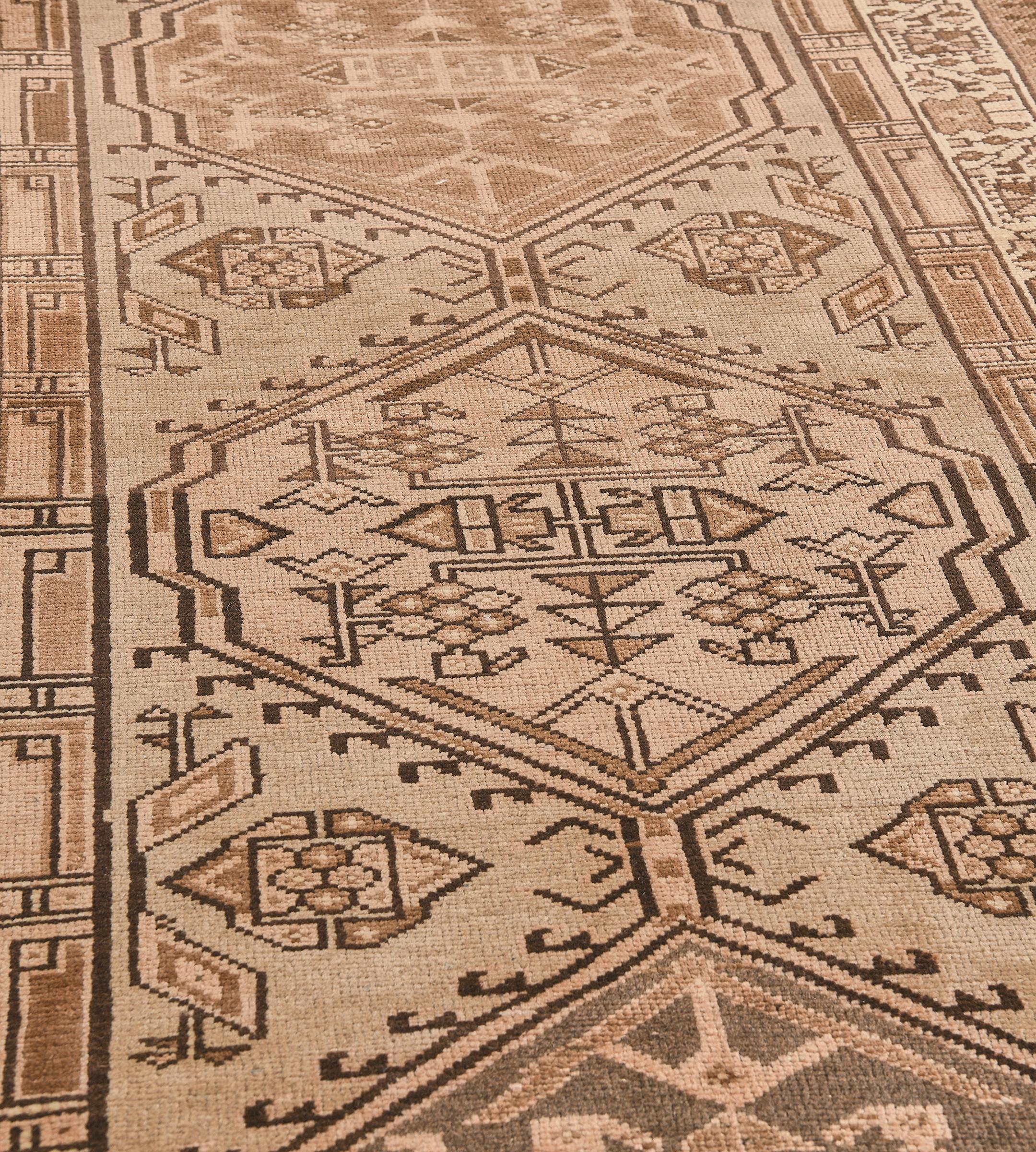 This vintage hand-woven Persian Heriz rug has a beige field with five hooked lozenge medallions enclosing geometric floral motifs, in an ivory geometric floral vine border, between tobacco stripes.