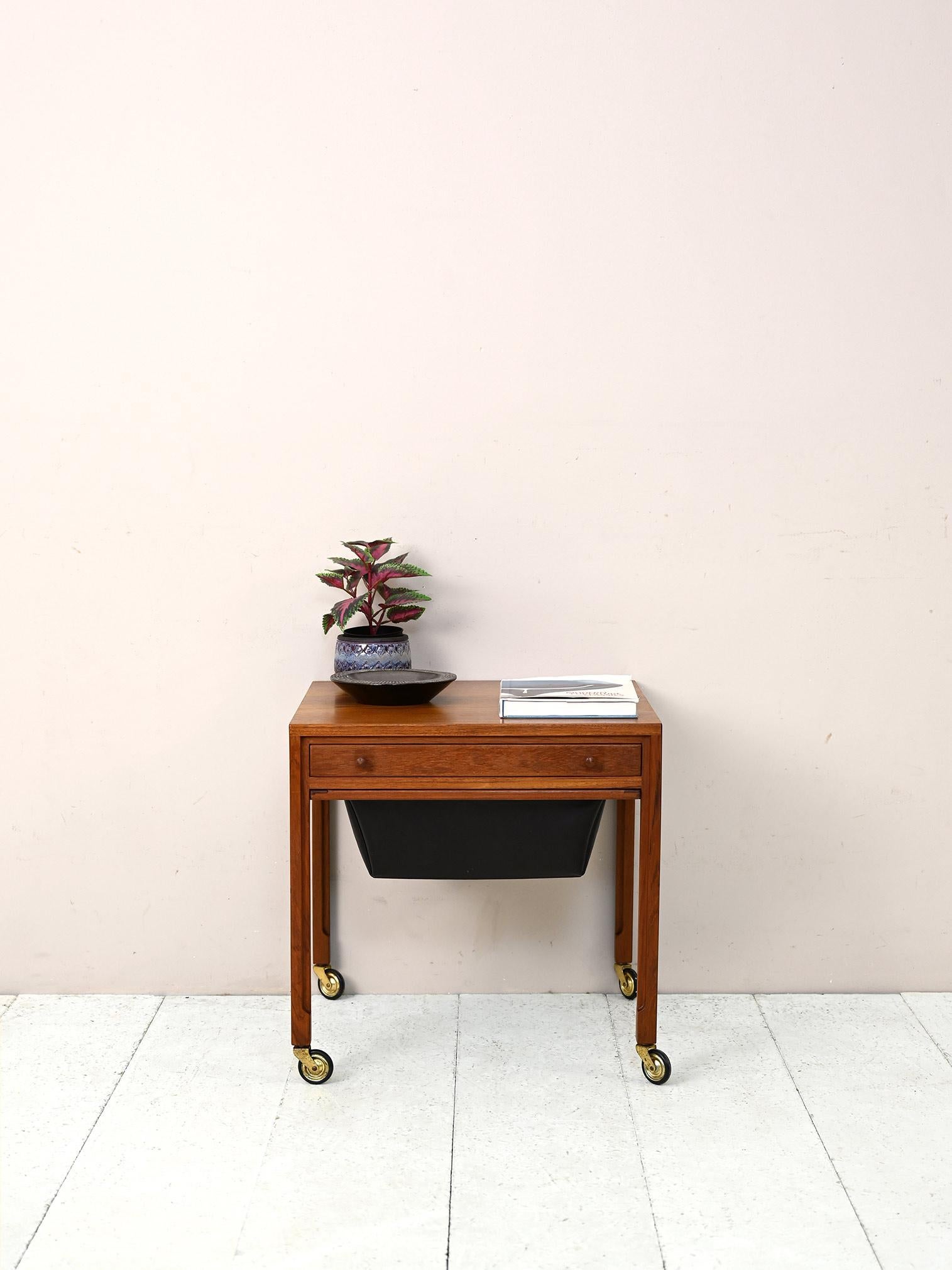 Chariot scandinave original avec tiroir et compartiment en similicuir noir.

Un meuble distinctif qui peut être utilisé comme table d'appoint pratique. Il y a un tiroir pratique et un compartiment de rangement. 
Parfait pour donner à la pièce un