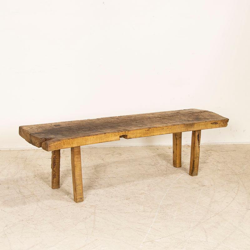 There is something organic and inviting in the thick wood top of this rustic square peg leg coffee table. It is the years of use that have deepened its character, with a wonderful worn patina grown richer over time.The heavy gouges, stains, cracks,