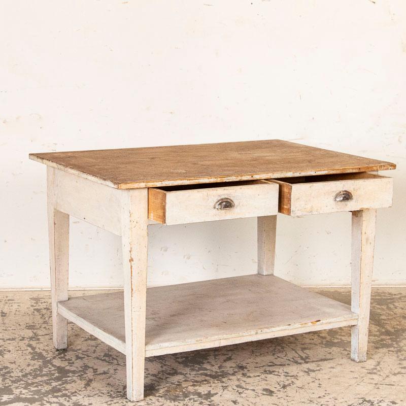 The charm of this work table comes from the combination of the pine top and original painted base. The natural pine top reflects generations of use as a work table, revealed in every ding, gouge and scratch. It is the original white painted base