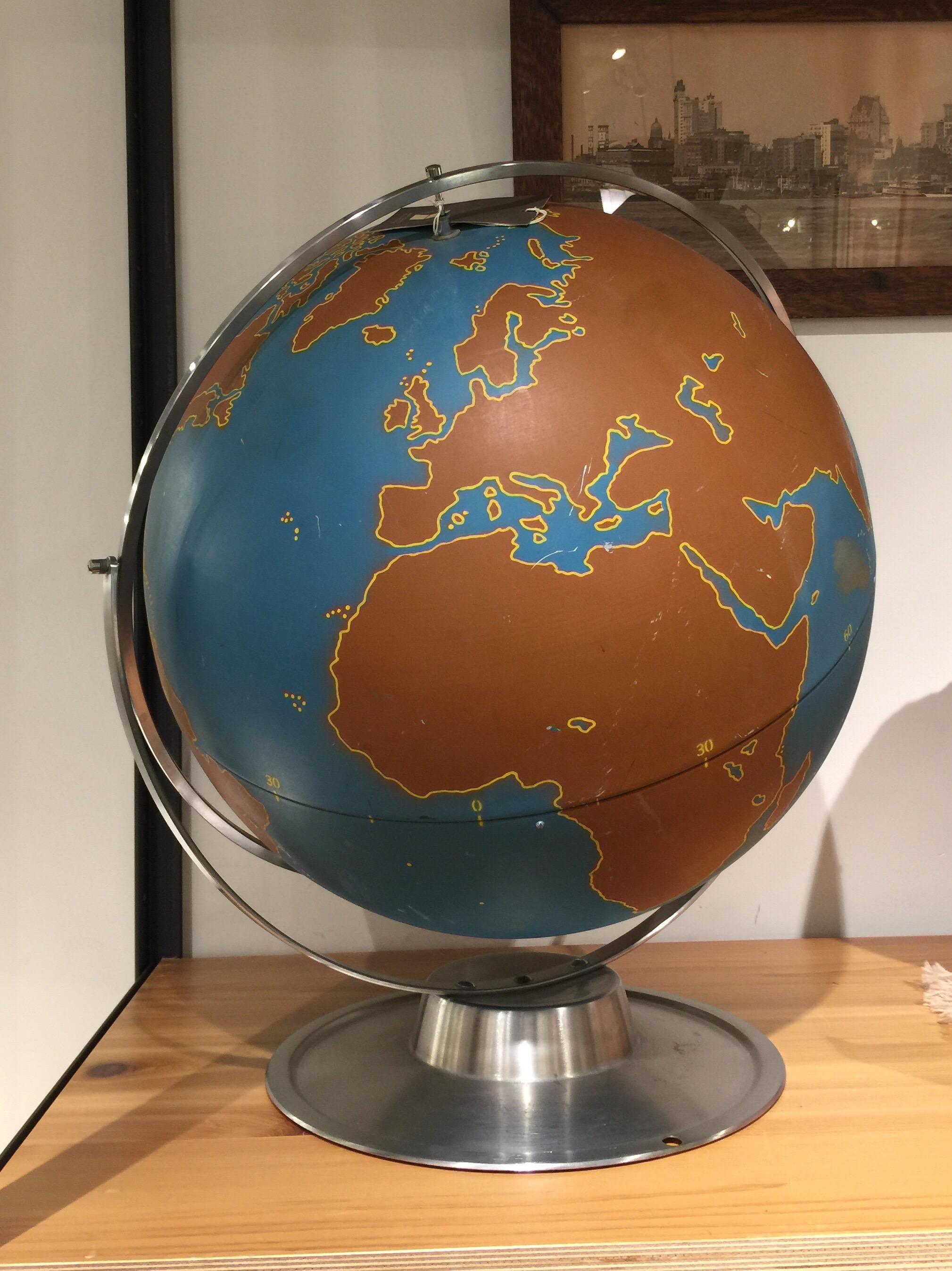 A vintage large school globe by A.J. Nystom Co. USA, circa 1950. 

Features delineated brown continents, along with oceans, latitude and longitude numbers against a blue ocean, but with no geographical names. Mounted on original round metal base