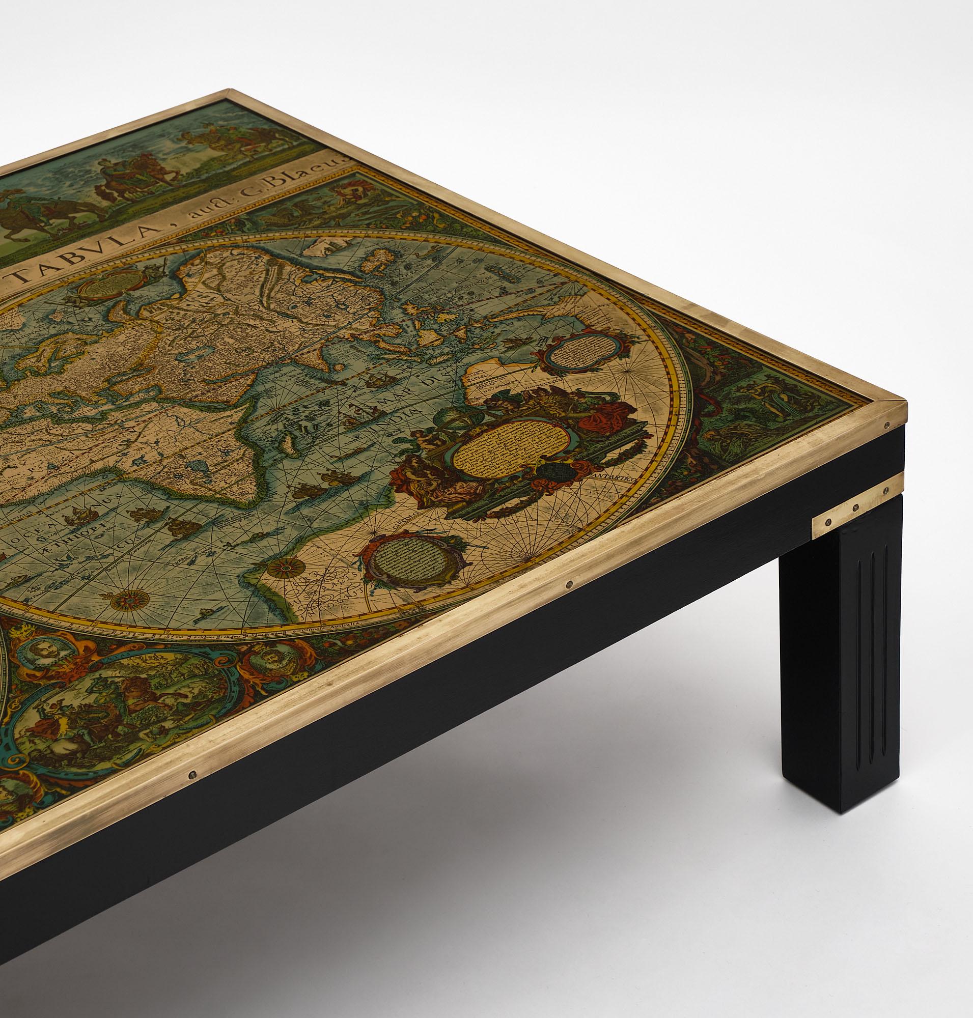 Coffee table from France made of ebonized wood featuring gilt brass trims with a clear glass top over a vintage map of the world. The map also includes equestrian portraits of royalties and a vignette of the Pope in the 17th century at the top with