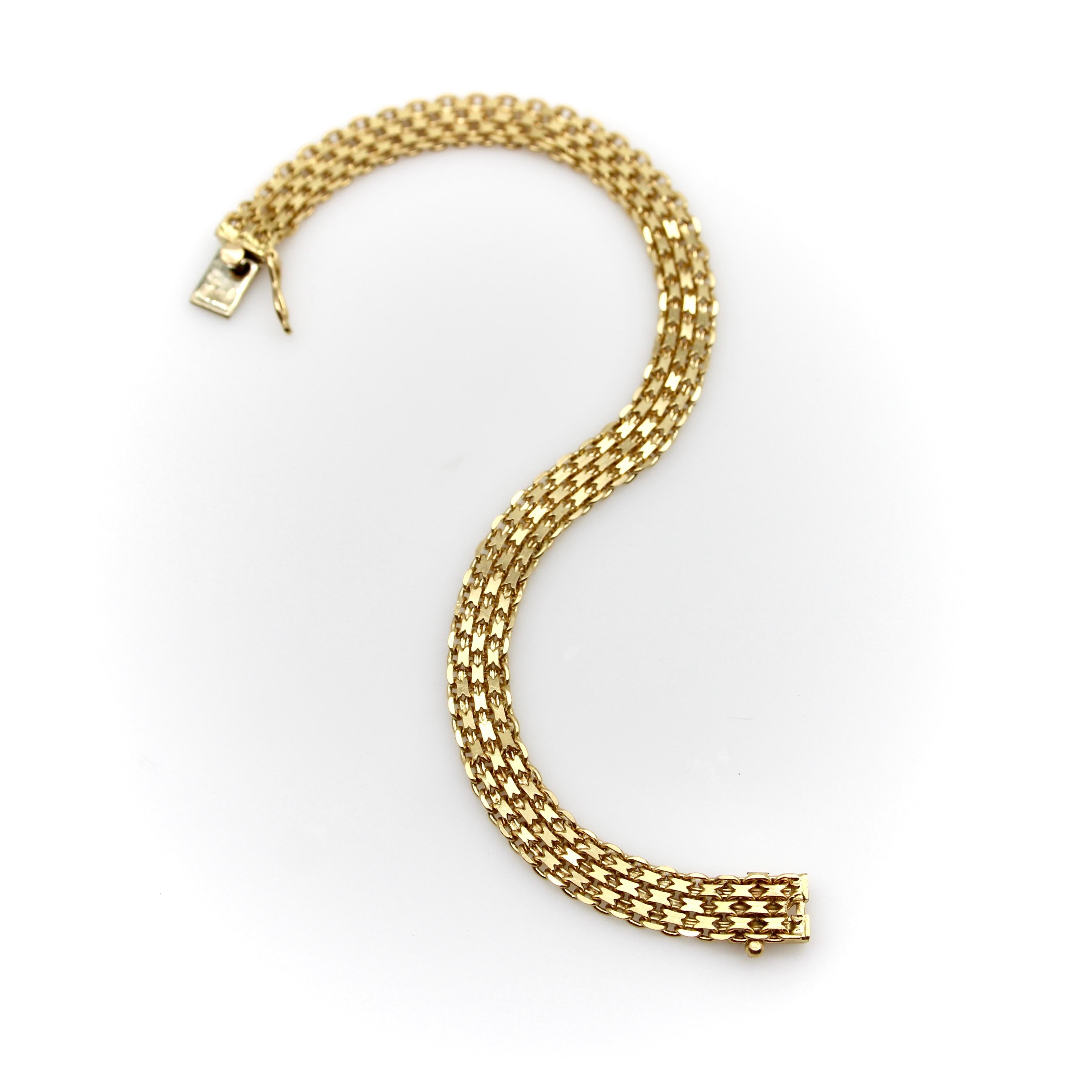 This is a woven 18k gold bracelet with interlocking links. The exterior links consist of flattened chain links that interlock into rows for a fluid mesh-like effect that shimmers in the light. This classic Bismark design flows on the wrist like