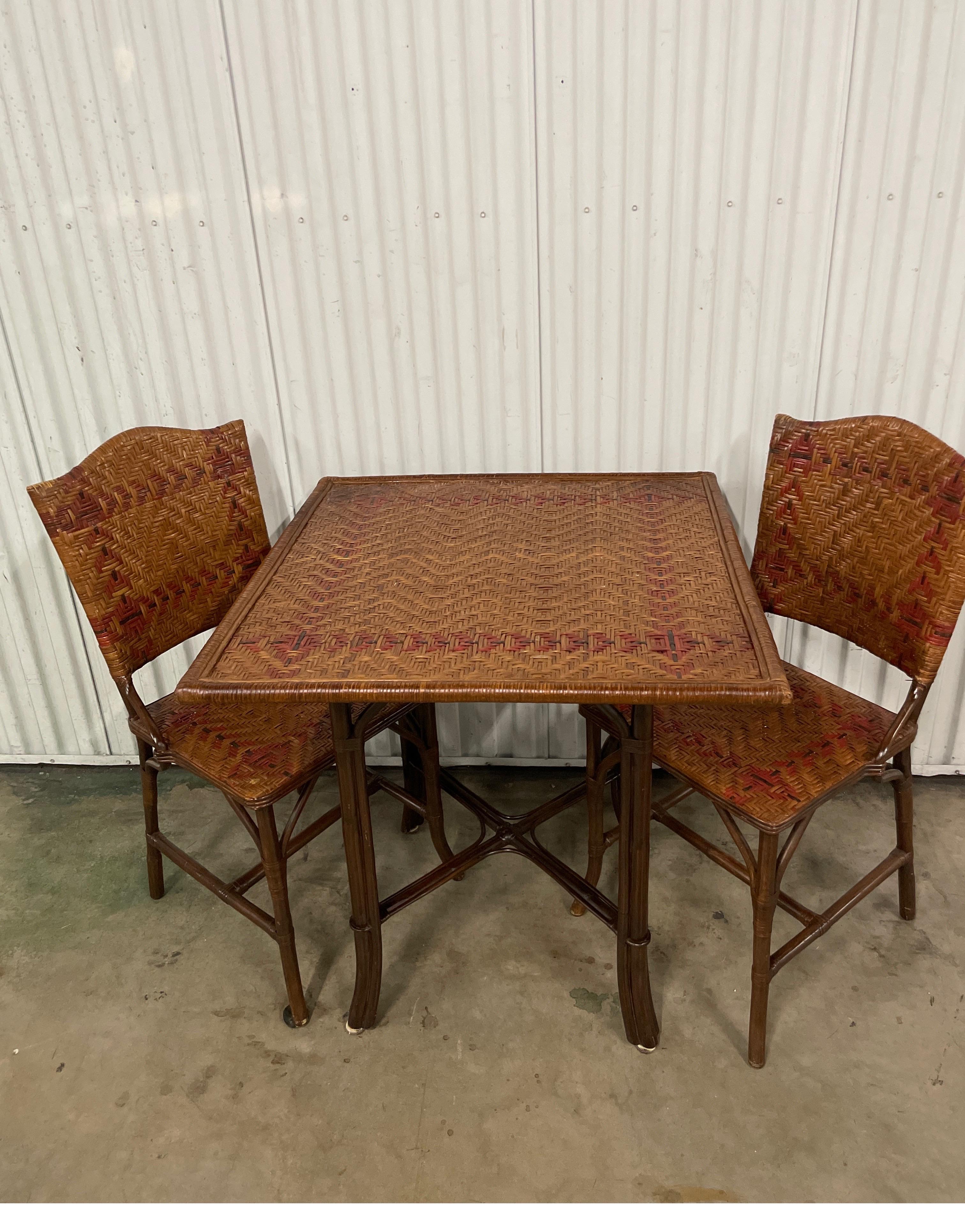 Vintage mid century woven bamboo table and two matching chairs. The chairs are 16