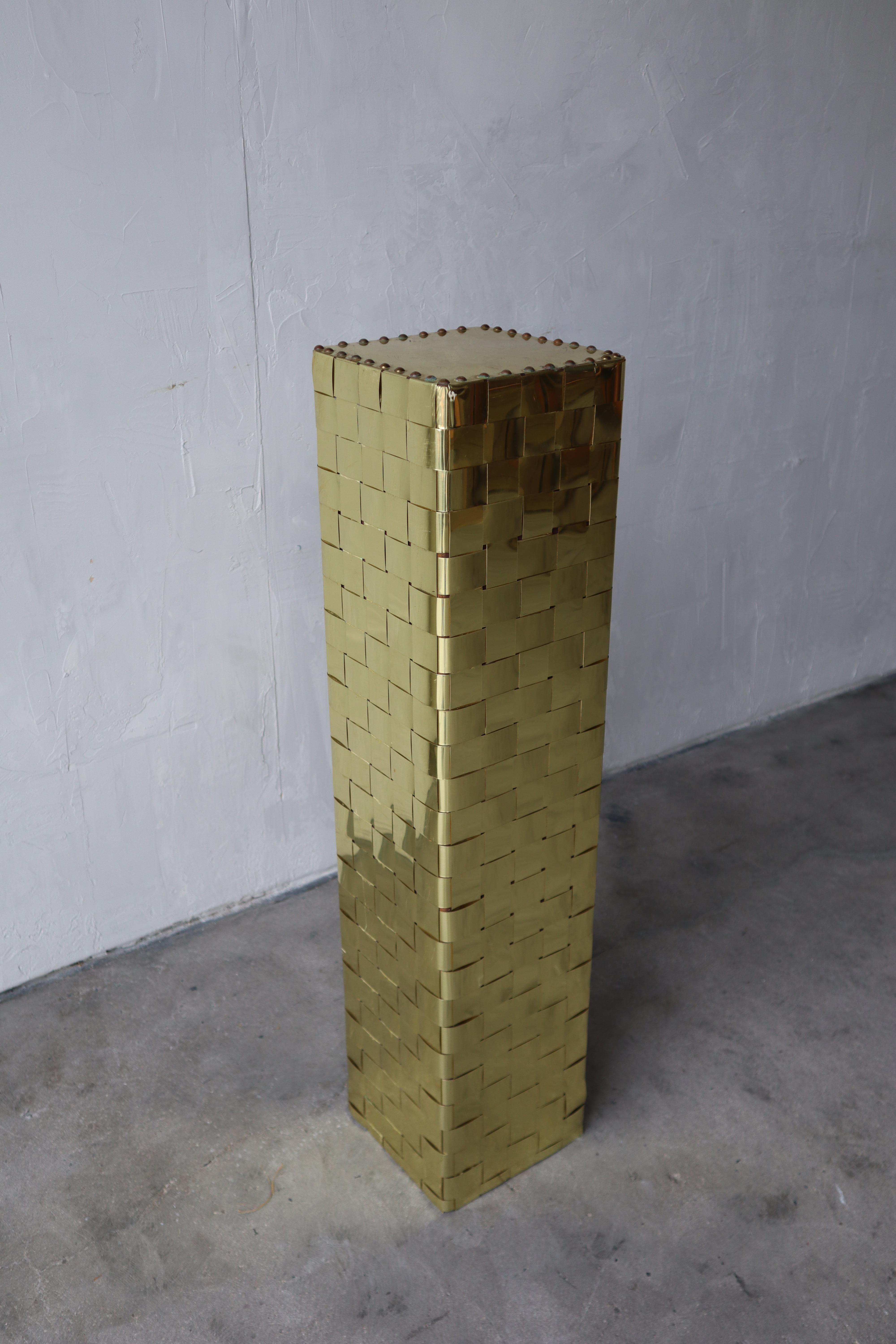 Unique pedestal, made of woven brass straps and studs.

There are some areas of minor patina, as to be expected with brass, but overall in great condition.