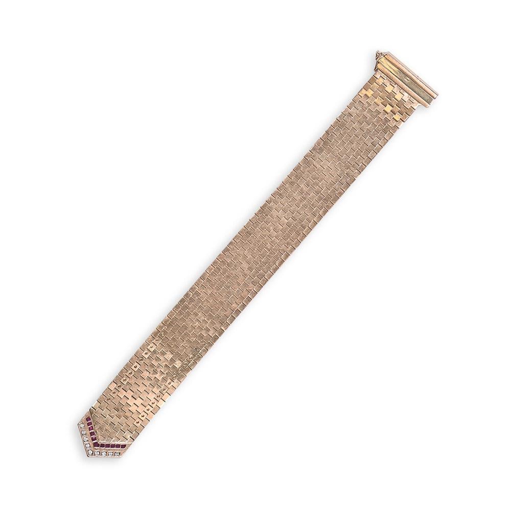 Step into the past with this vintage bracelet, meticulously crafted from 14k yellow gold links woven together. The clasp showcases a captivating blend of round brilliant-cut diamonds and calibre-cut rubies in a geometric pattern. The diamonds weigh