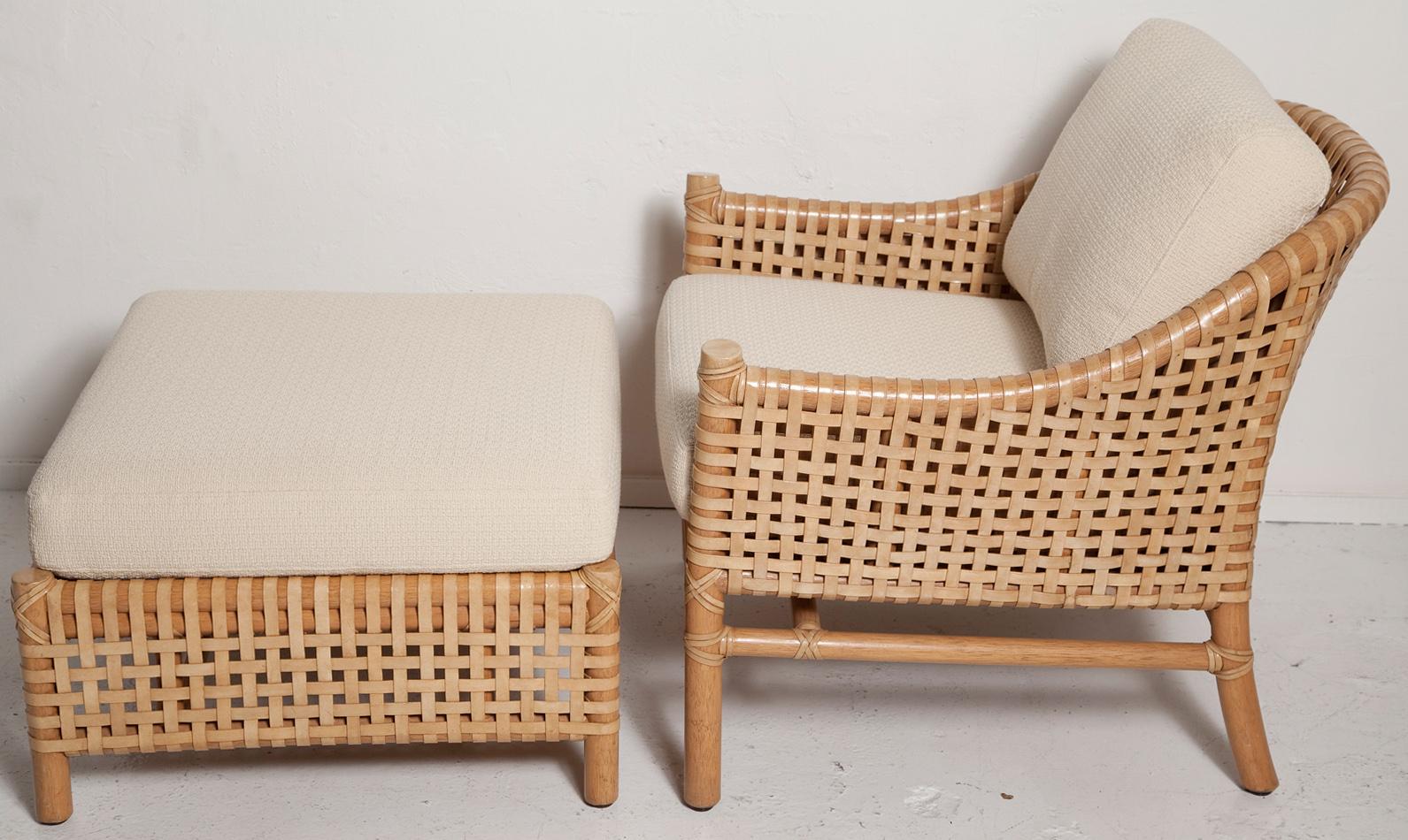 An eye-catching vintage lounge chair and ottoman set by McGuire made entirely of rawhide leather straps woven onto a thick bamboo frame. Near mint condition with new textured cotton upholstery. This circa 1980 set retains its original brass McGuire