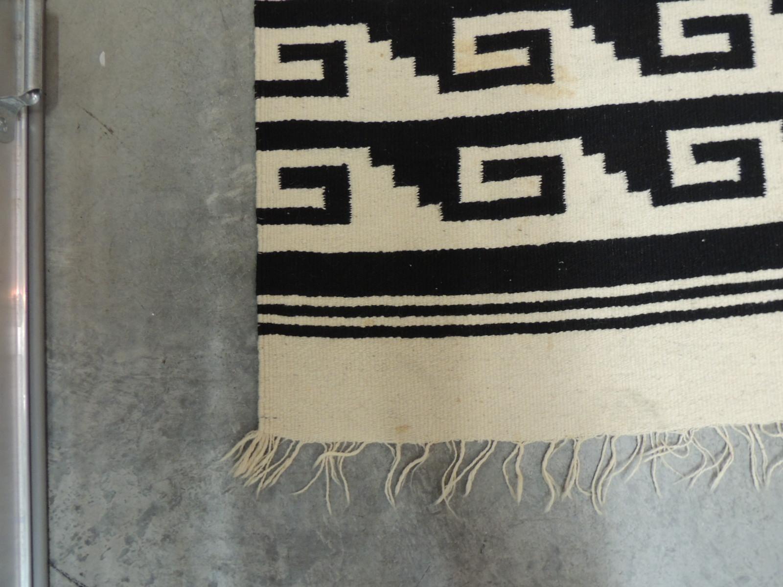 Vintage woven natural and black Peruvian flat-weave rug or throw
with hand knotted fringes.
Size: 47