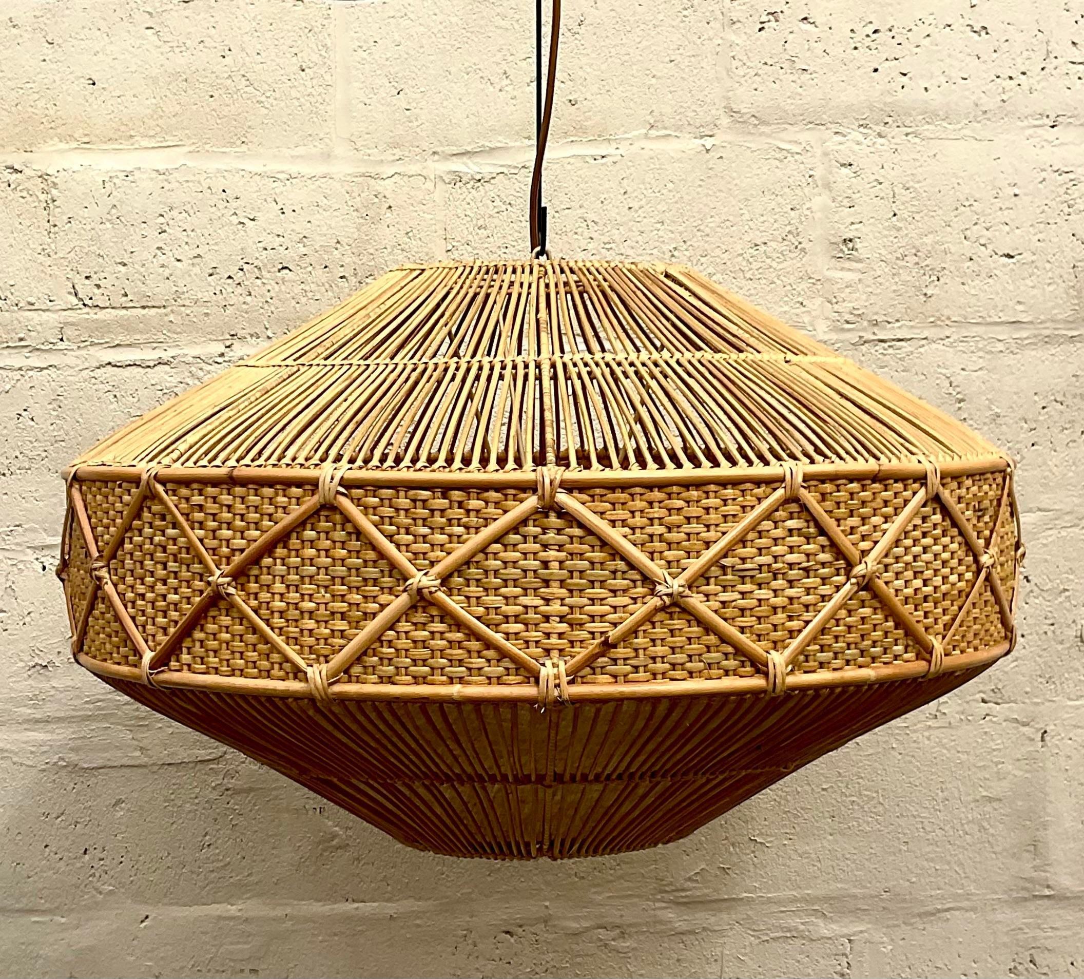 An absolutely stunning vintage chandelier made out of woven rattan. It is a perfect light source for a coastal home. A chic diamond shape with a ring of diamond rattan. Acquired from a Palm Beach estate.