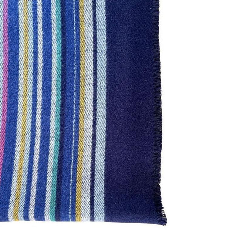 A gorgeous vintage wool throw blanket in navy blue, green, yellow, and red. This vintage throw will be a great accent to a library or den, draped over a cozy chair. Or on a covered patio with a fire. It is rectangular and has a plain navy blue