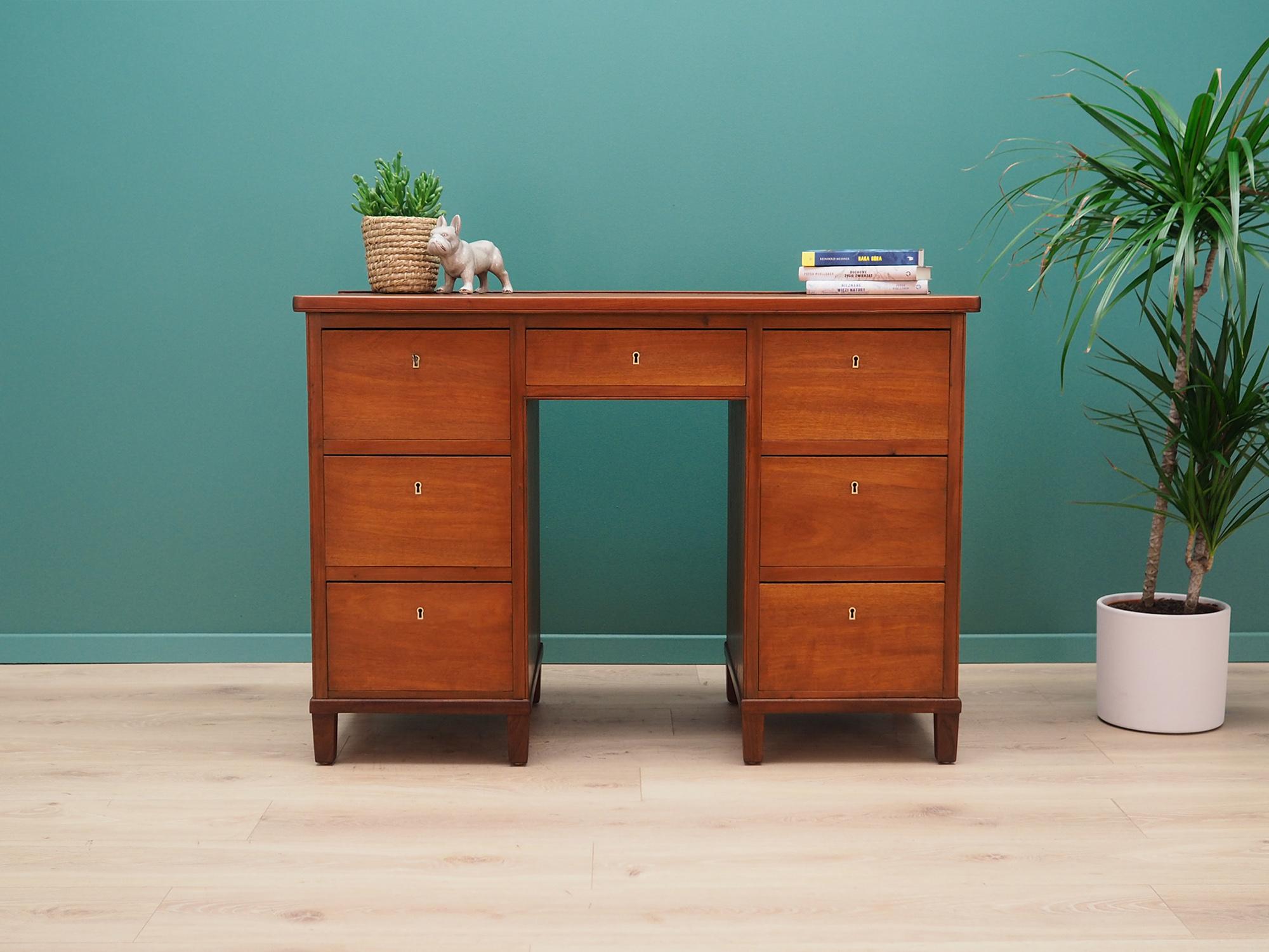 Sensational desk from the 1960s-1970s. Minimalist form, Scandinavian design. The furniture is covered with teak veneer, legs are made of solid teak wood. The desk has seven spacious drawers and a key included. Preserved in good condition (small