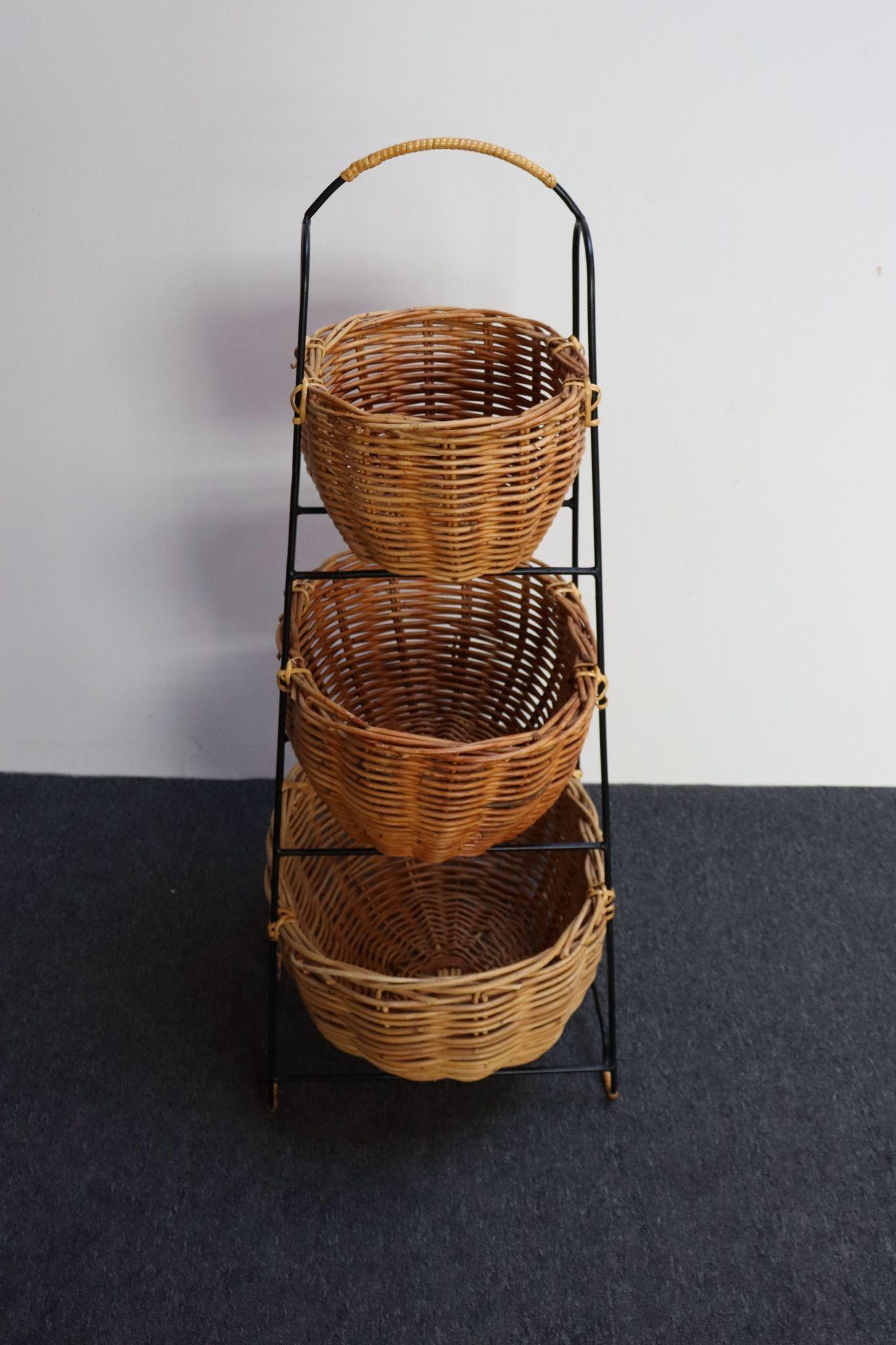 Portaoggetti americano d'epoca composto da tre cestini di canna graduati di tre dimensioni montati su un supporto in ferro battuto.
Esempio della fine degli anni '70/inizio anni '80, il cui design originale è stato leggermente modificato e copiato