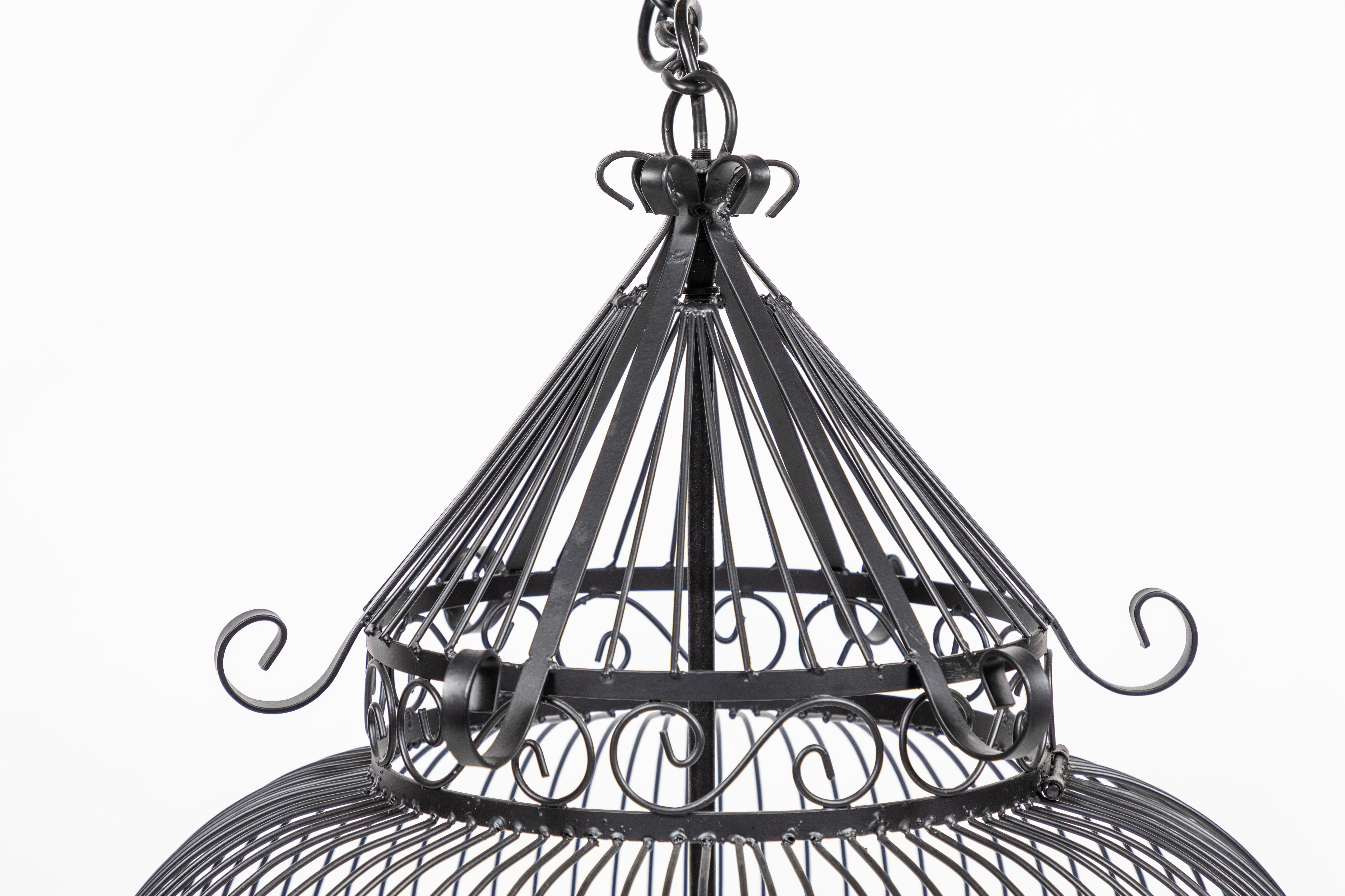 A vintage wrought iron birdcage with new black painted finish and newly wired and made into a hanging light.

Style lends to Victorian, chinoiserie and midcentury.