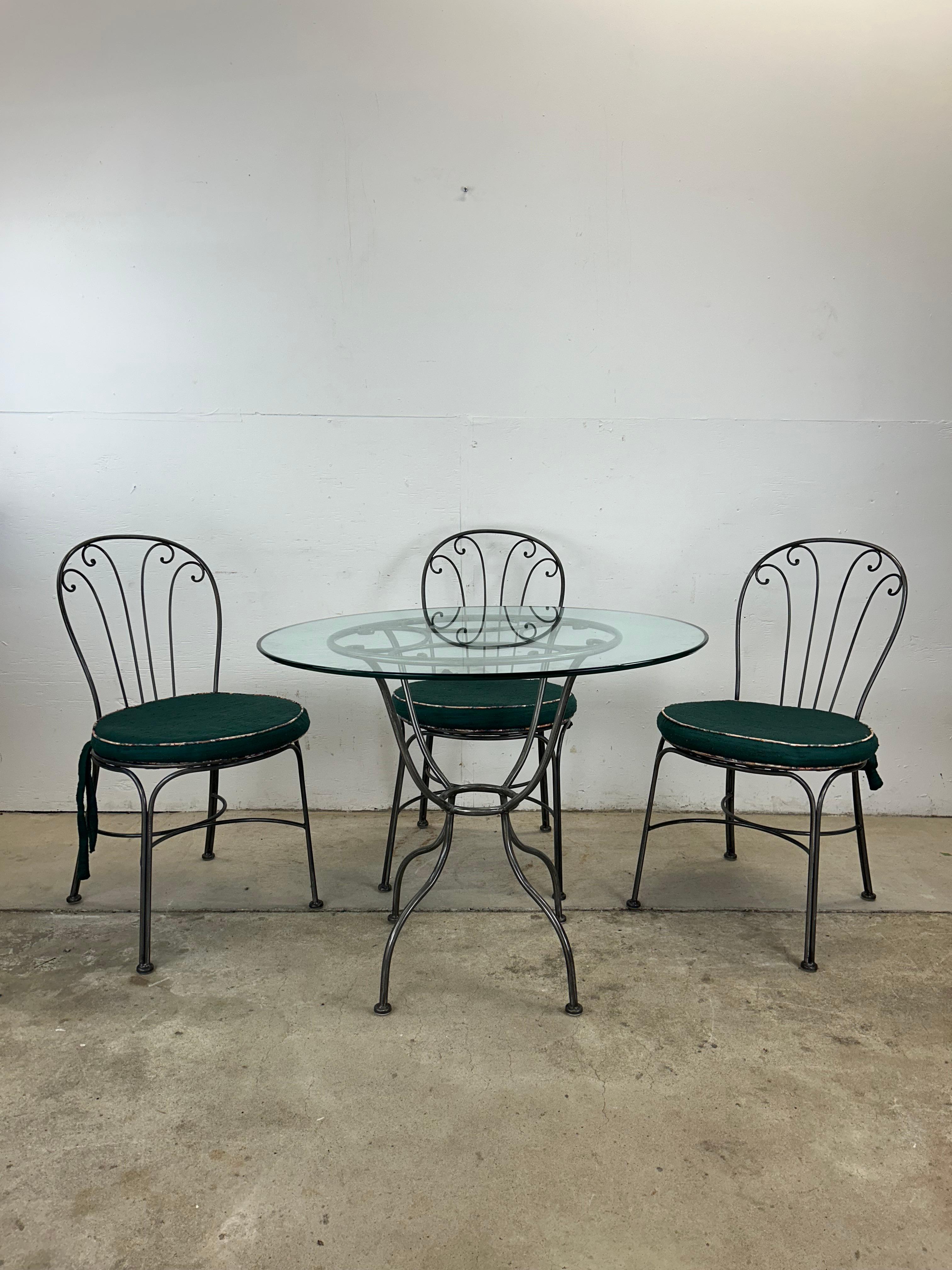 Cet ensemble bistrot vintage comprend une table en fer forgé avec un plateau rond en verre et trois chaises. Ces airs riches sont dotés de coussins verts amovibles et d'assises en métal tressé.

Dimensions de la chaise : 19w 23d 35.5h 20sh