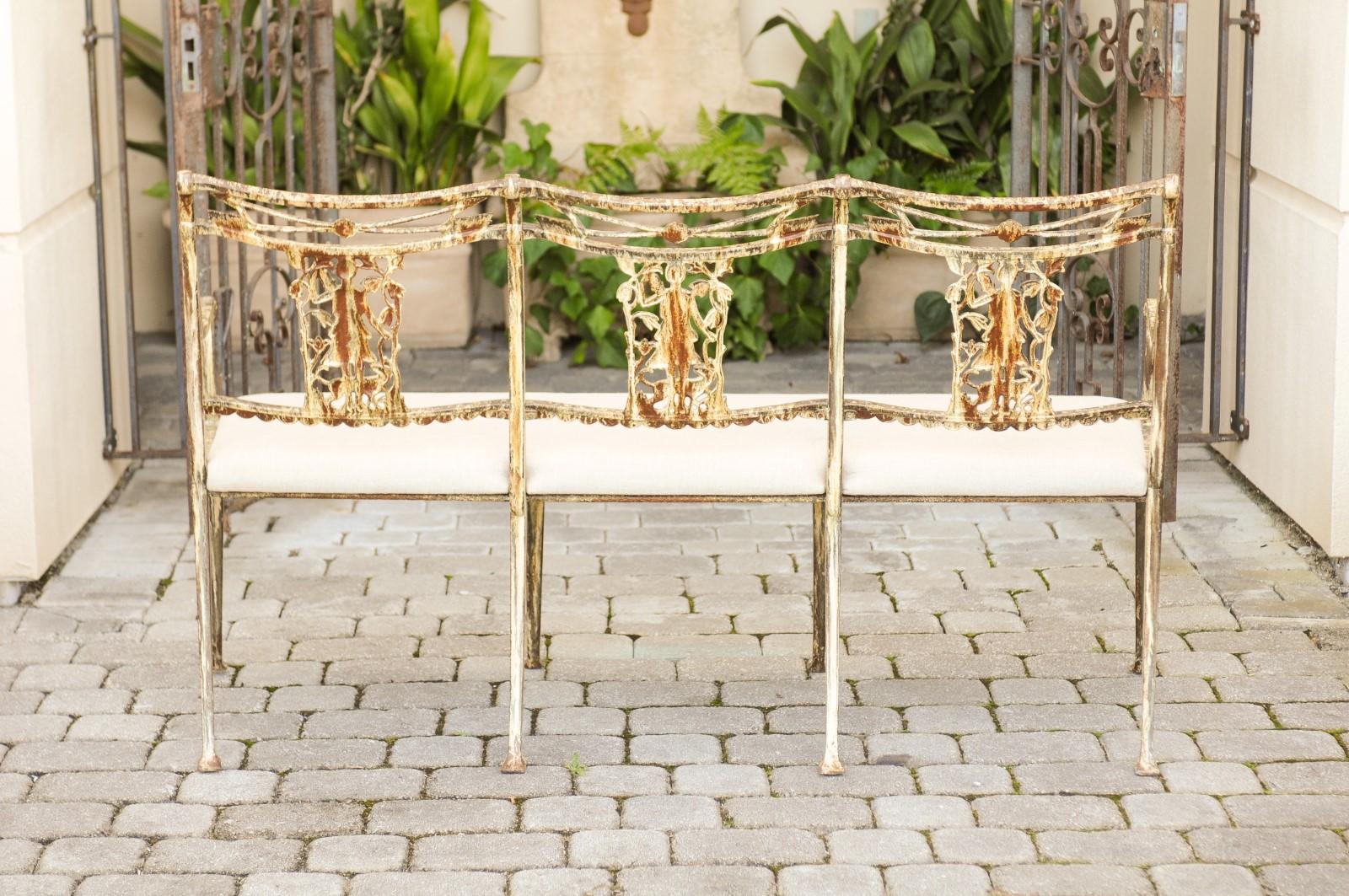 A Molla painted wrought iron upholstered garden bench from the mid-20th century depicting Diana, goddess of the hunt and her arrows. Created in the midcentury, this exquisite iron bench features a nicely weathered painted finish. Revealing its
