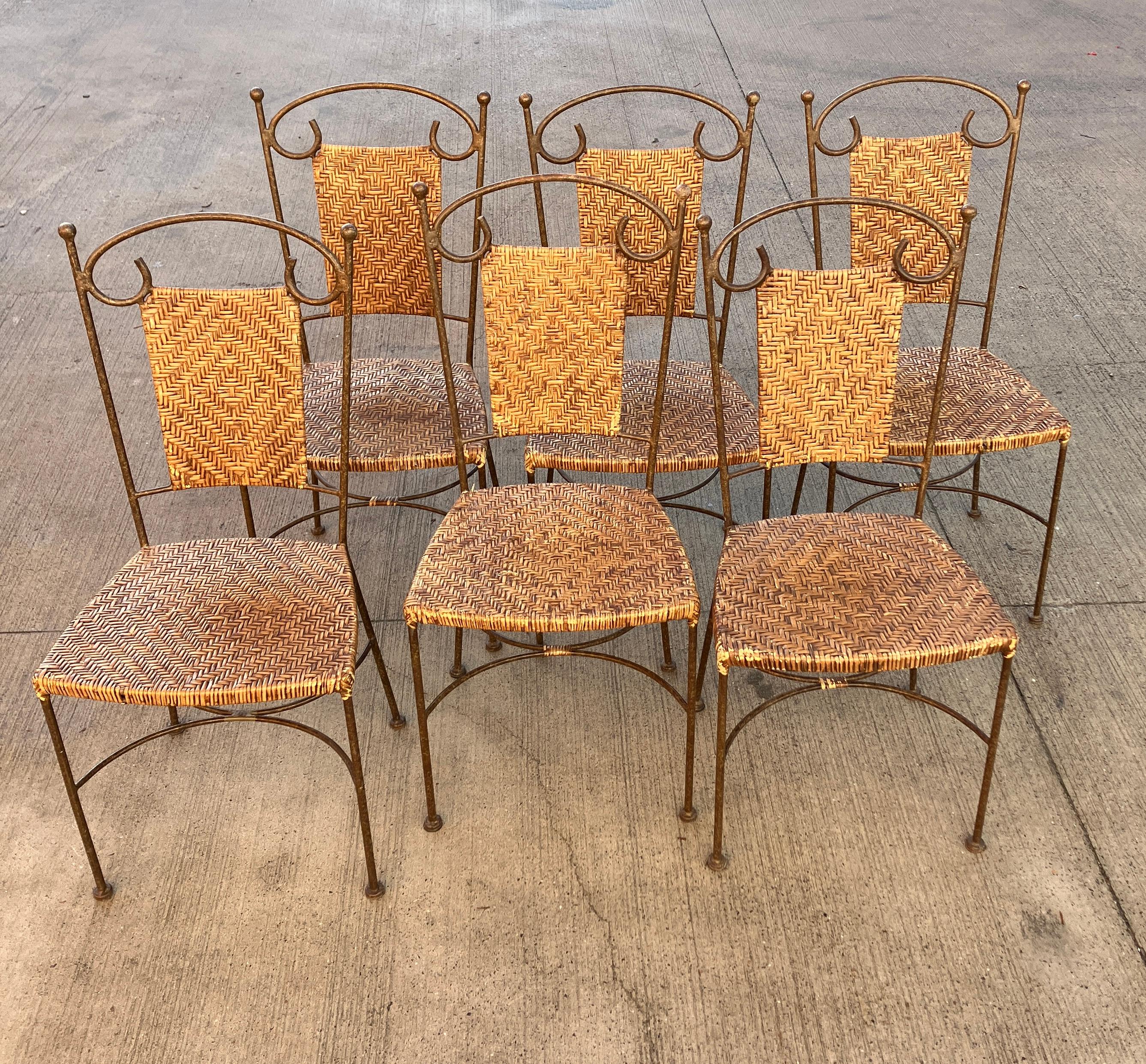 Six vintage dining chairs with gorgeous wrought iron bases and wicker seats and backrests. The wrought iron chairs have a simple elegant form with some curved metalwork for decoration. An attractive vintage dining chair collection.  

The chairs
