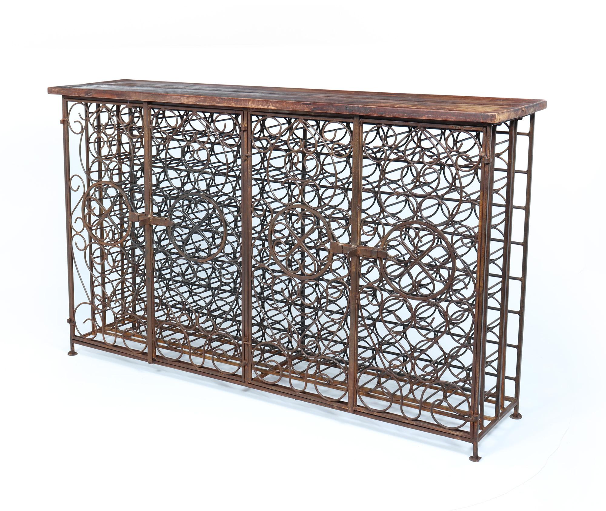 Vintage  Iron French Wine Rack
A vintage French Wrought iron wine rack produced in the 1960’s storing 112 bottles behind a sliding lock, the cabinet has four hinged doors of beautifully crafted scrolling iron work. The solid wooden top has age