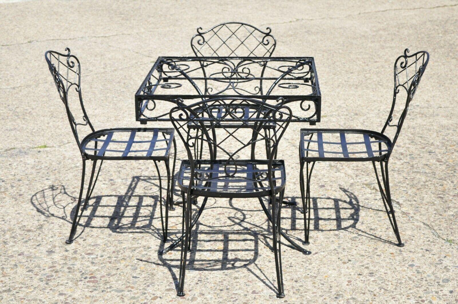 Vintage Wrought Iron Garden Patio Dining Set Square Table 4 Chairs - 5 Pc Set. Item features (4) Side chairs, (1) Square dining table, unique scroll work design, fretwork backs, very nice vintage set, great style and form. Circa Mid 20th Century.