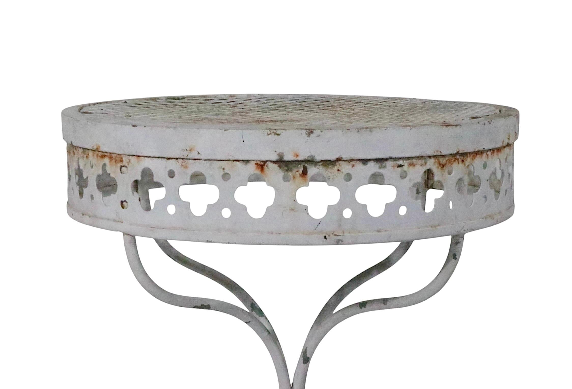 Schicker kleiner Garten-, Terrassen- und Pooltisch aus Schmiedeeisen und Metallgeflecht von Salterini aus der begehrten Taj Mahl Serie, ca. 1950er Jahre. Der Tisch verfügt über eine Metallgitterplatte mit dem charakteristischen vierblättrigen