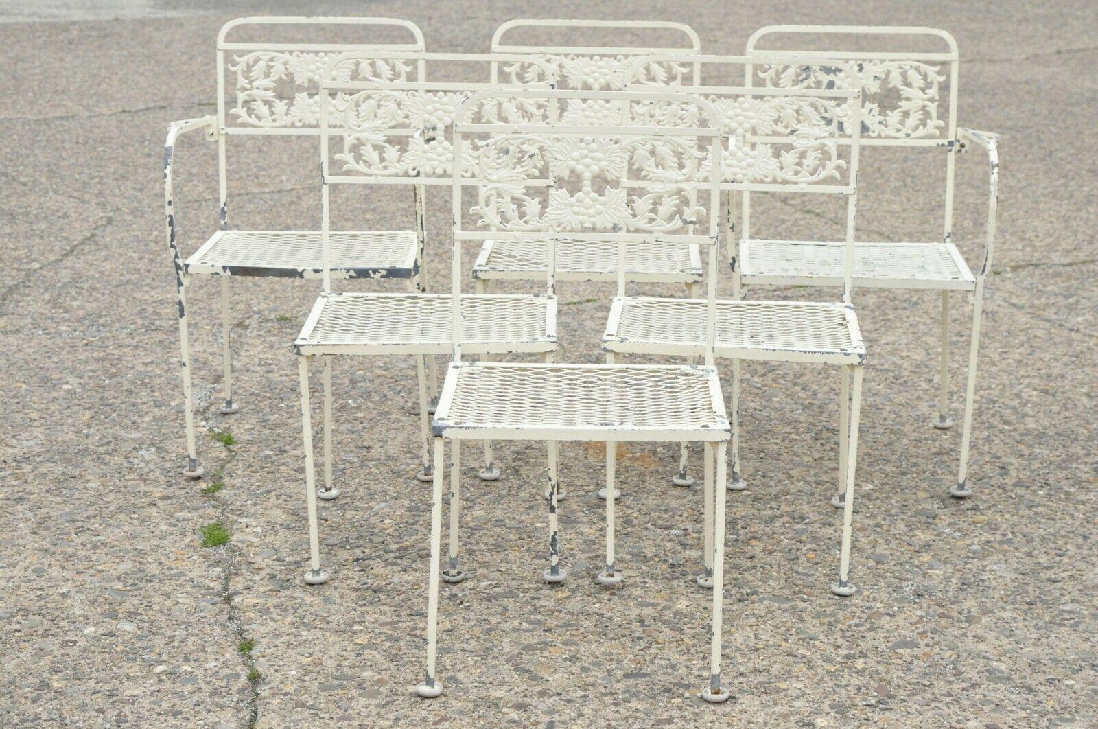 Vintage wrought iron grape leaf garden patio dining set table 6 chairs - 7 Pc Set. Item features (2) armchairs, (4) side chairs, (1) glass top table, floral scroll work design, wrought iron construction, very nice vintage set, great style and form.