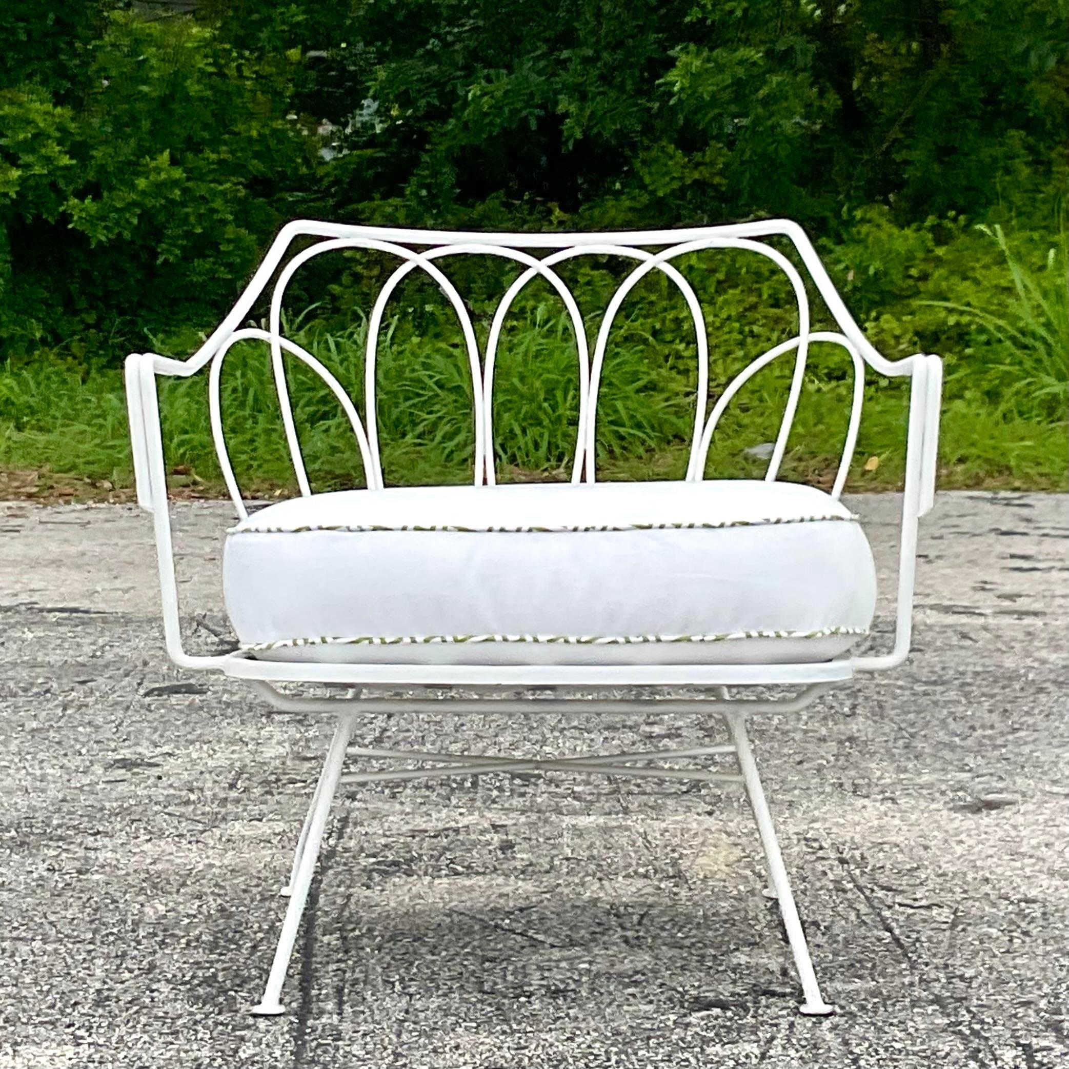 A fabulous vintage MCM outdoor lounge chair. Done in the manner of Maurizio Tempestini for Salterini. Chic looped wrought iron in a painted white finish. Coordinating cushion with contrast green welting. Matching sofa also available on my page.