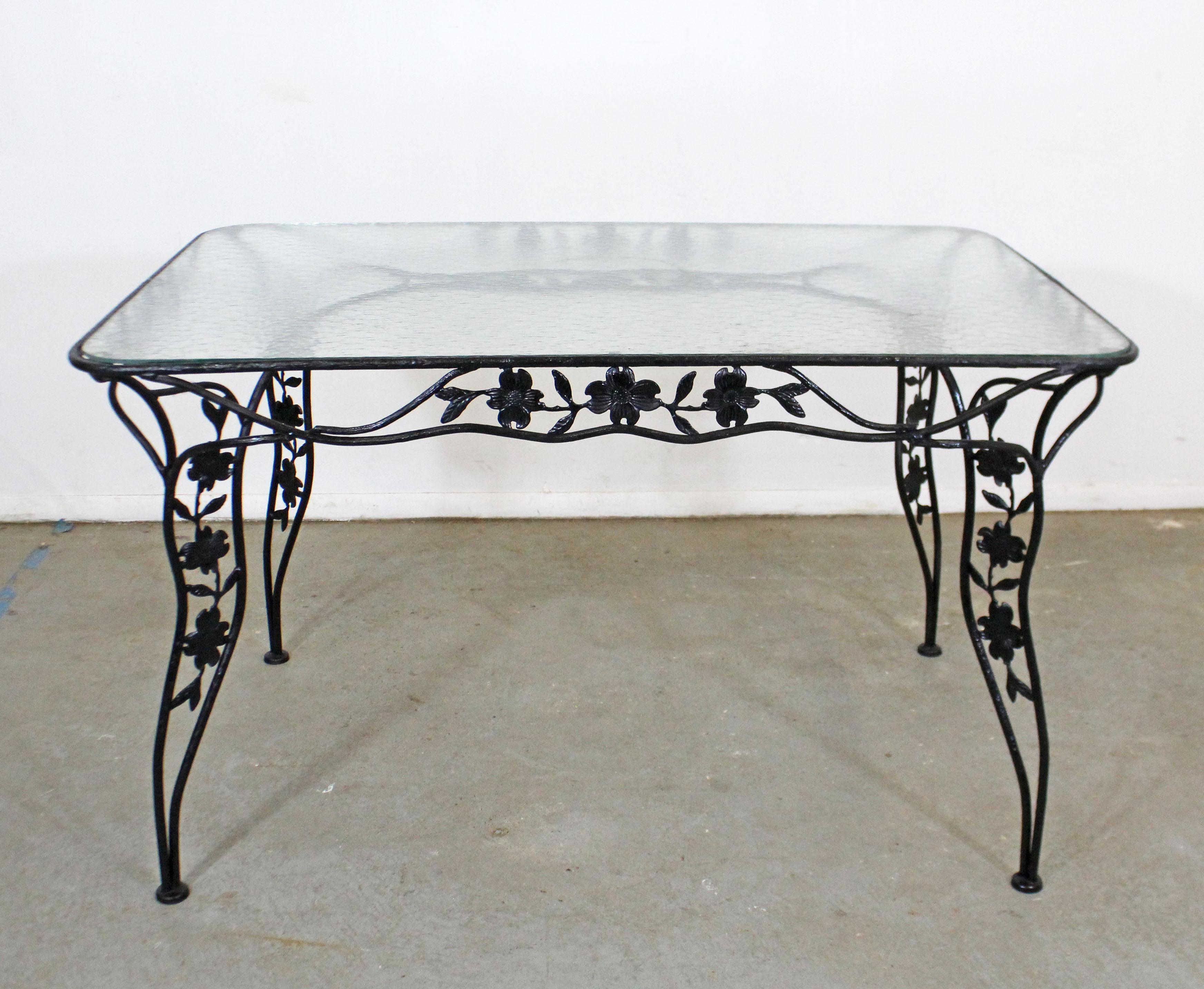 What a find. Offered is a vintage wrought iron dining table with a dogwood-leaf design and a removable glass top. Perfect for an outdoor patio space! Attributed to Meadowcraft's 'Dogwood' line. It is in good condition with a repainted and