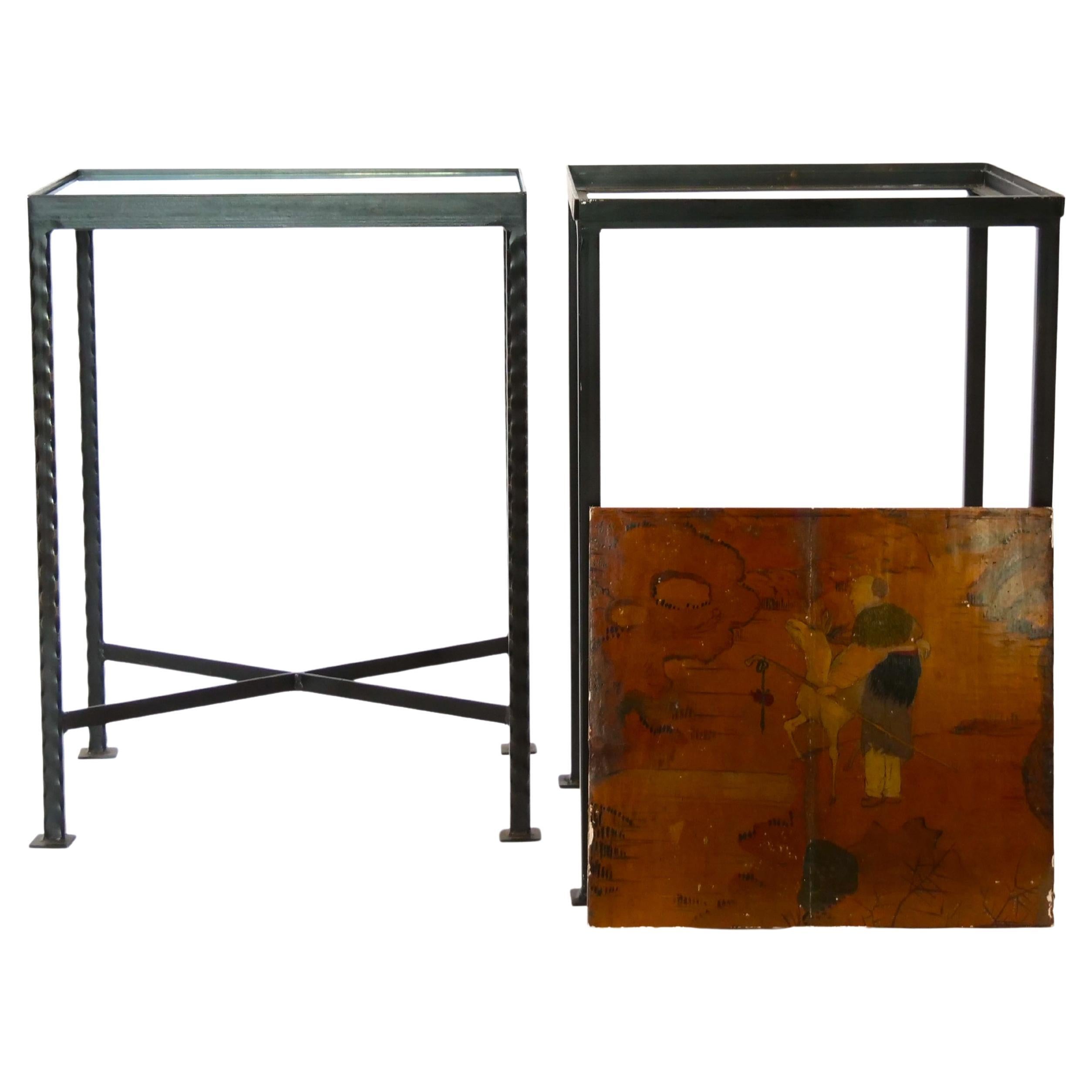 Late 20th century pair black wrought iron framed with hand painted wood top side table. Each table features a removable hand painted wood top design details resting on a squared frame wrought iron metal base. Each table is in good condition with