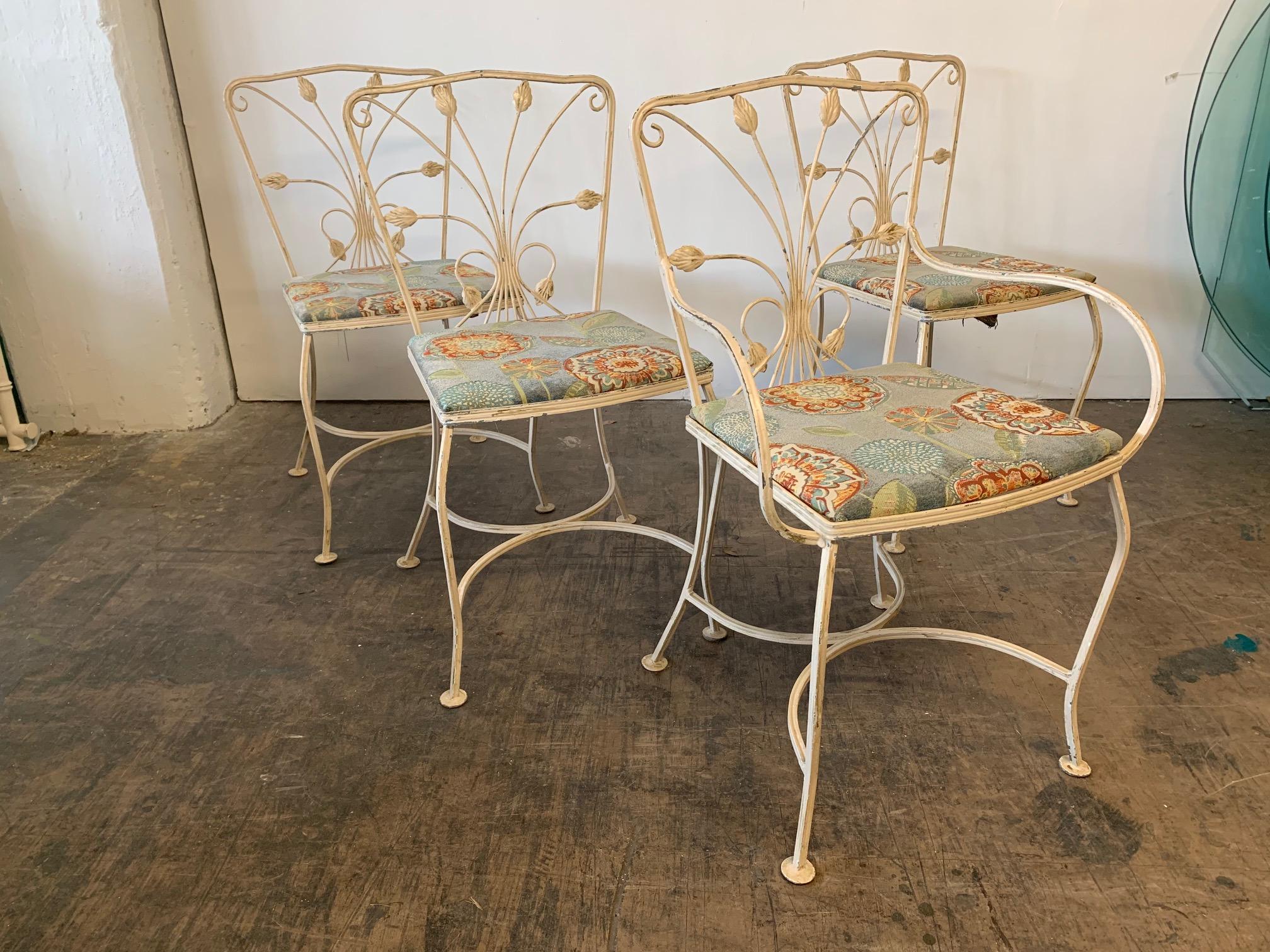 Vintage wrought iron patio set features leaf motif detailing and glass top table. Good vintage condition with some paint loss to original finish.
Table measures: 42.5