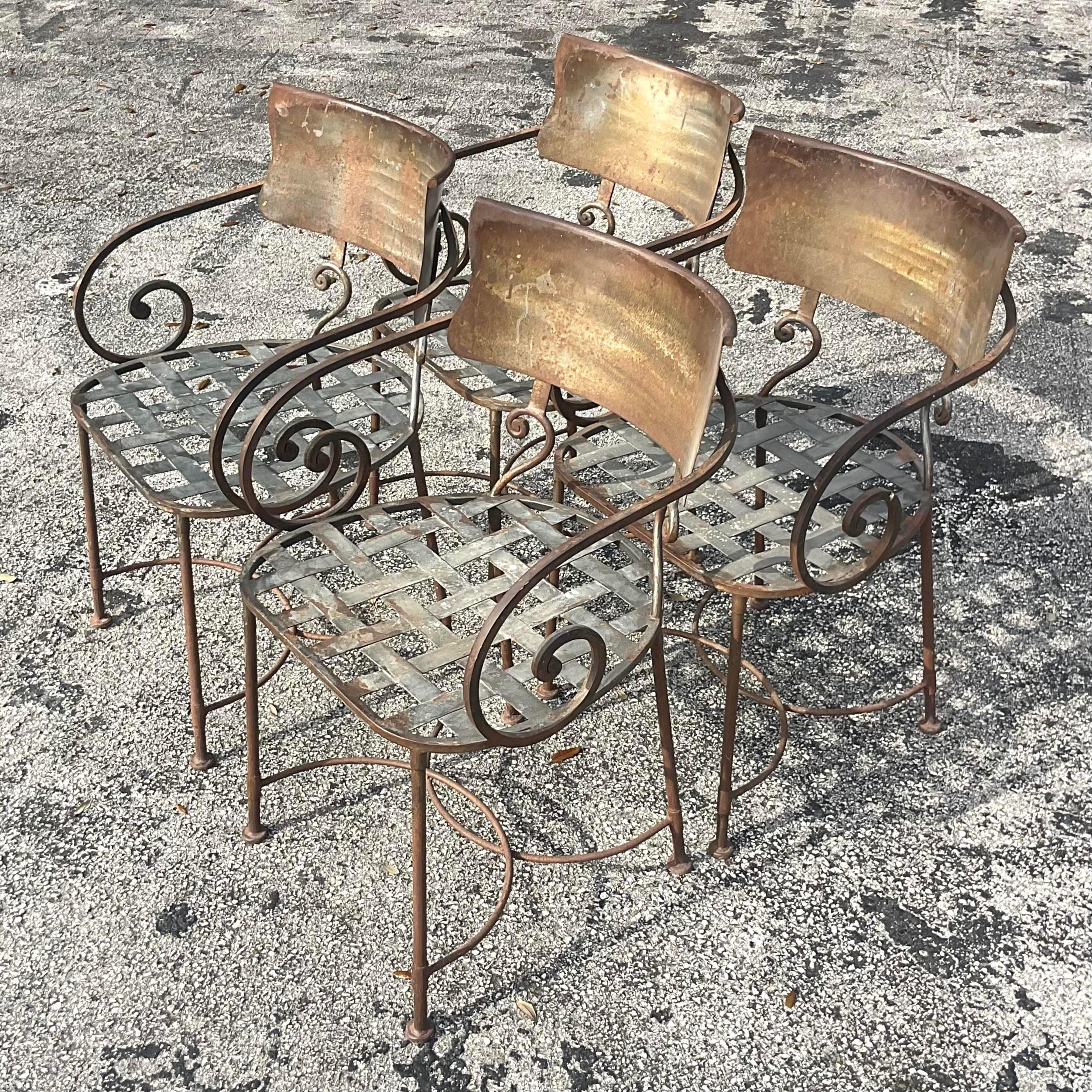 A genius set of 4 vintage wrought iron chairs. Beautiful scroll arm with wide panel backs. Dramatic and comfortable. Currently they have the patina of areas of rust. I think they look fantastic, but would be easy to powder coat with a bright clean