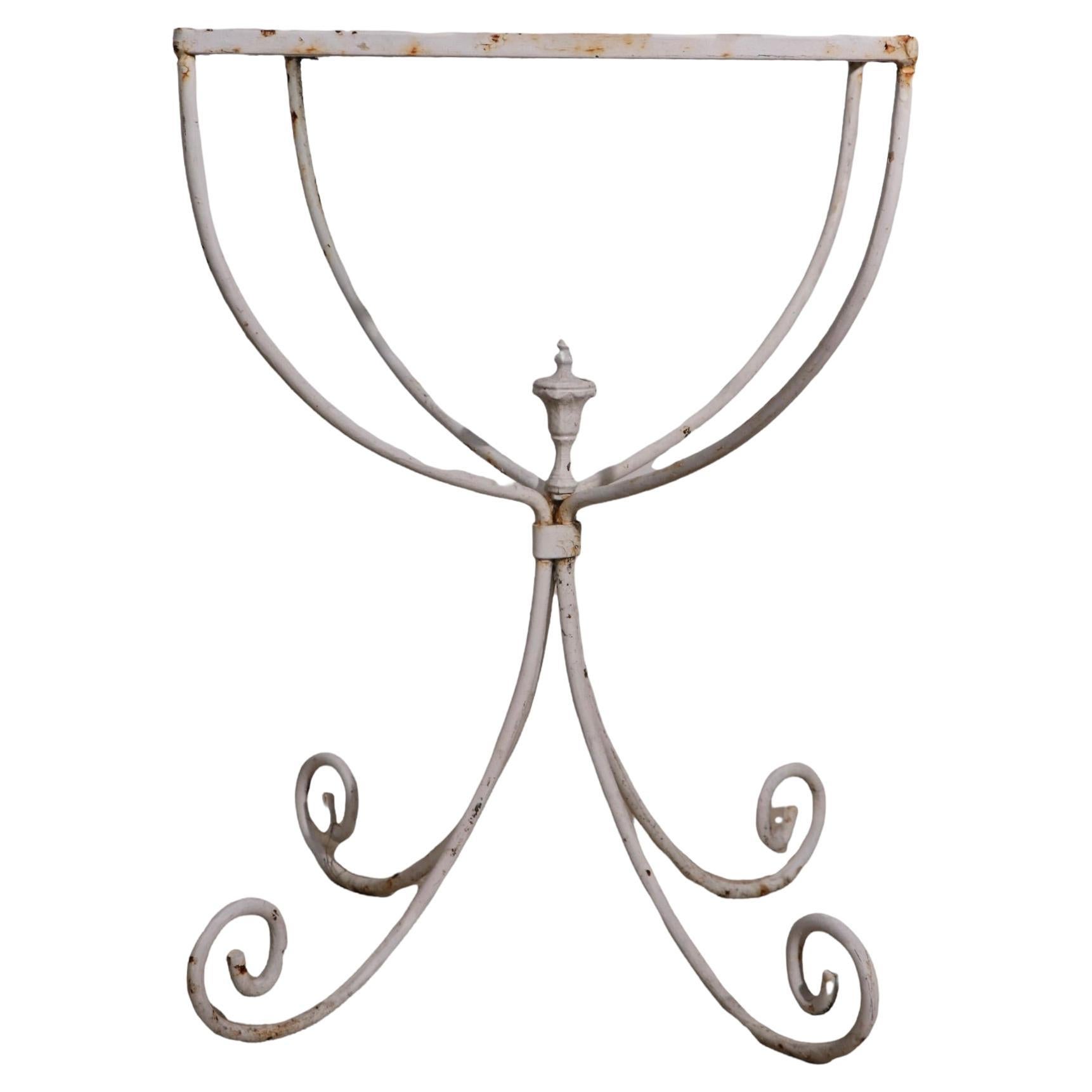 Charming diminutive side, or end table of Romantic and Classical form. The table features a U shaped body which supports the original glass top, on scrolling curlicue feet, with a center urn finish as an added decorative touch. This delightful stand