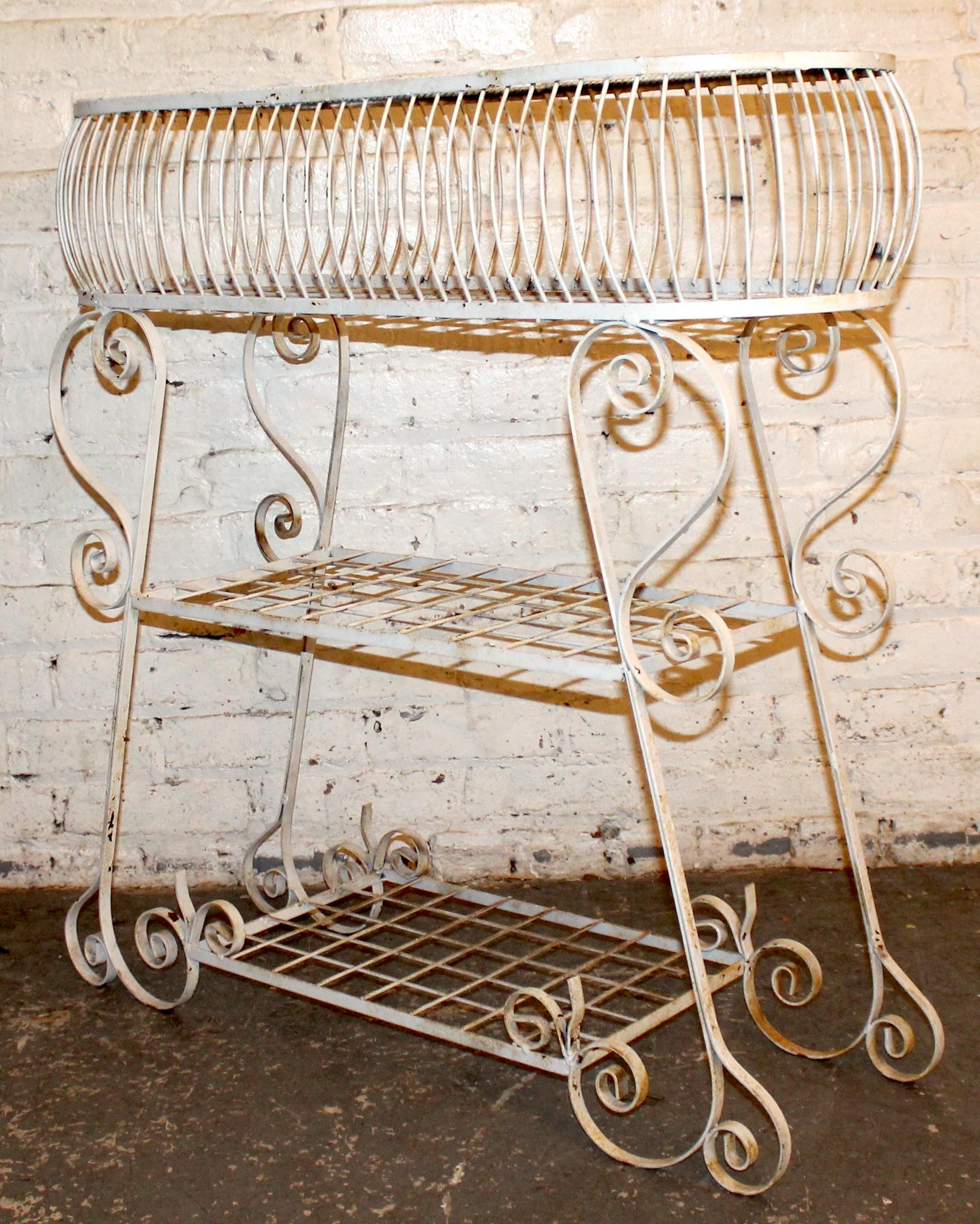Charming three-tiered plant stand crafted from sturdy wrought iron, featuring elegant scrollwork and a gracefully tiered design. Perfect for showcasing plants indoors or out, with a timeless vintage patina that adds character and style.

Please