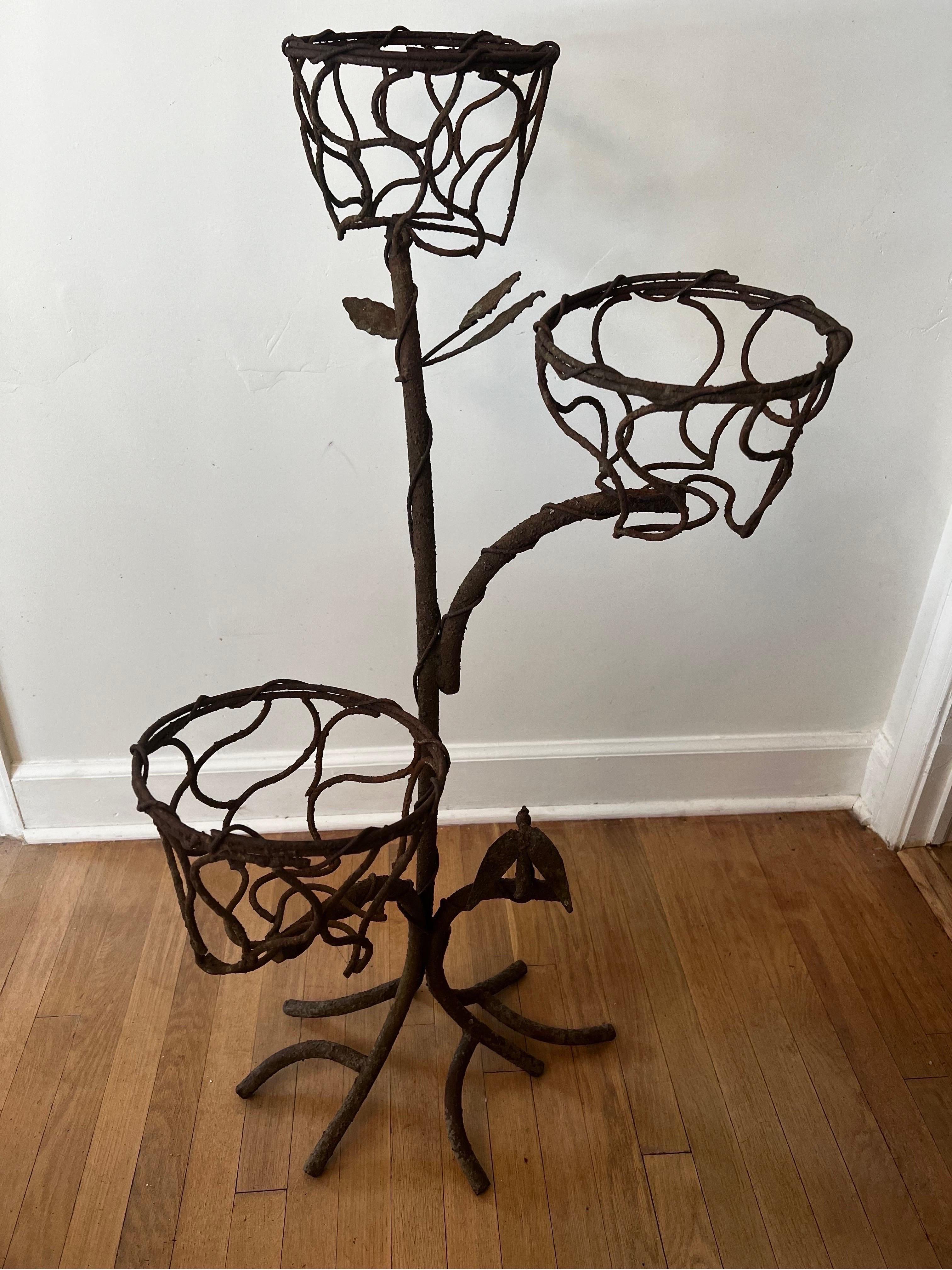 Unique one of a kind wrought iron plant stand in the style of Giacometti. 
Branches with leaves and a signature bird nestled at the bottom.

3 tiers all in solid condition to hold plants with pots or left as is.  Dried boxwoods pictured are NOT