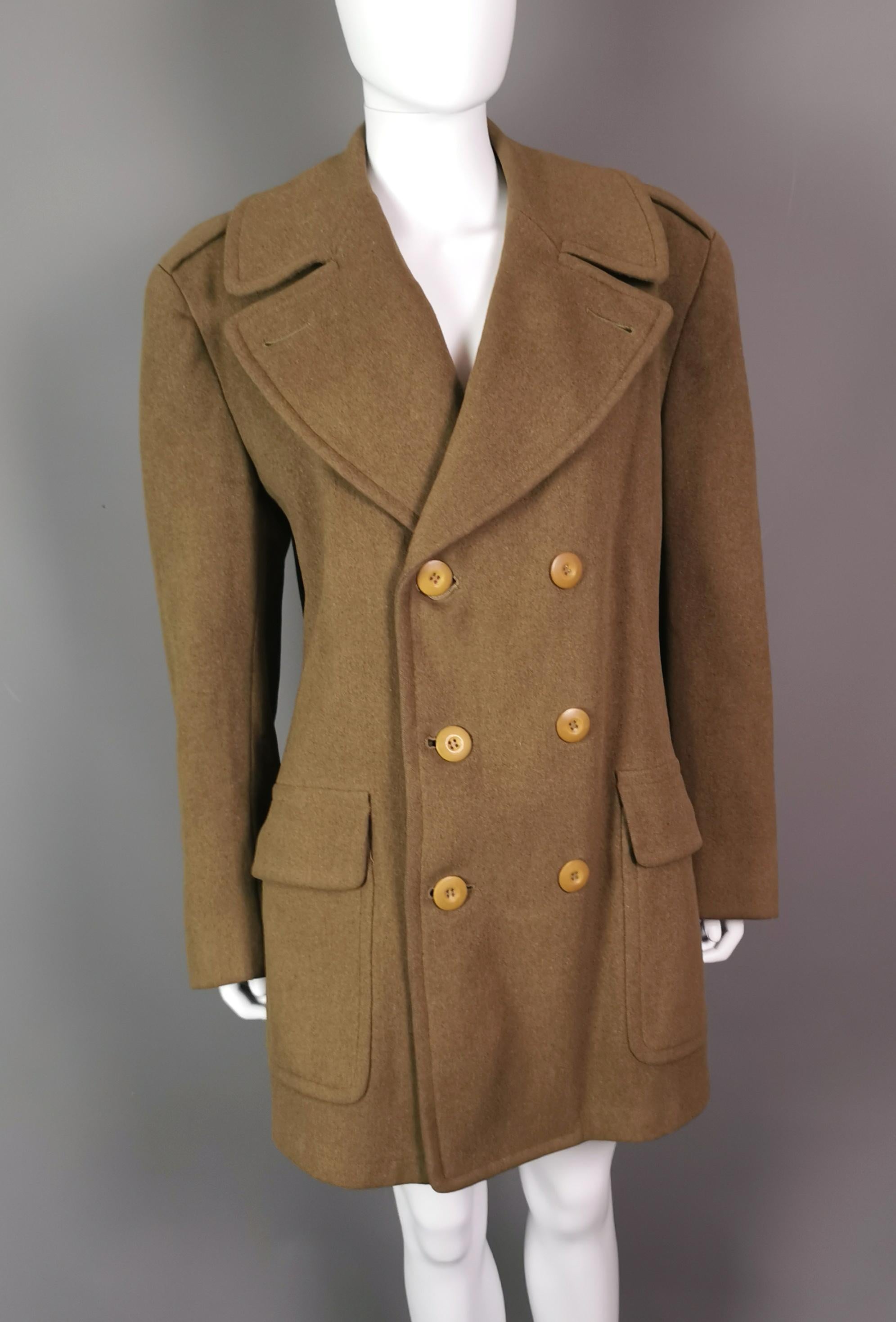 A fabulous vintage 1940's British Army officer's overcoat.

Khaki Green, land officer, Regulation overcoat, with label, it has deep mustard coloured bakelite type buttons, internal pockets and is a double breasted coat.

It is cut very thick and