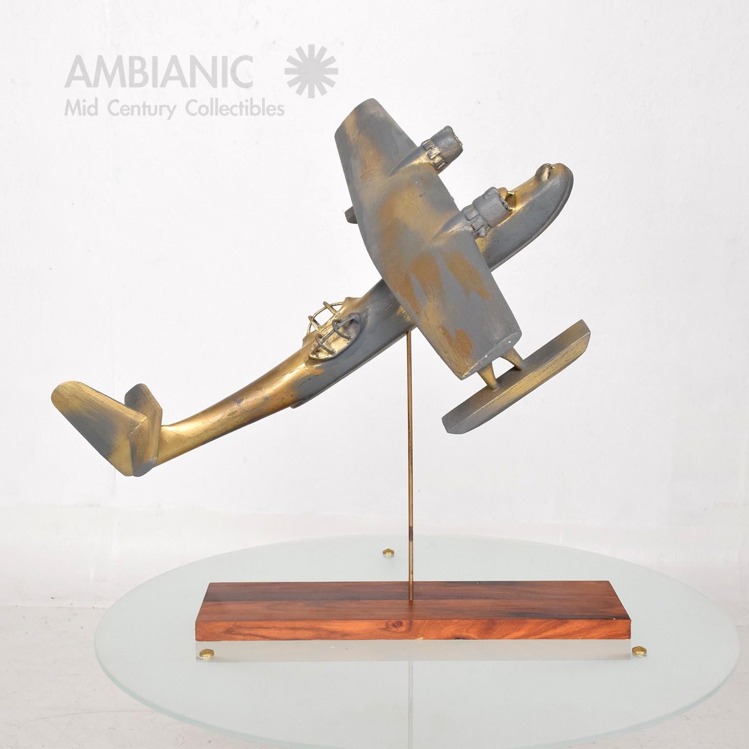 Airplane Art
Vintage WWII wood Airplane sculpture mounted on a brass rod with rosewood base. Fabulous faux Patina.
No information on maker.
Dimensions: 18 3/8