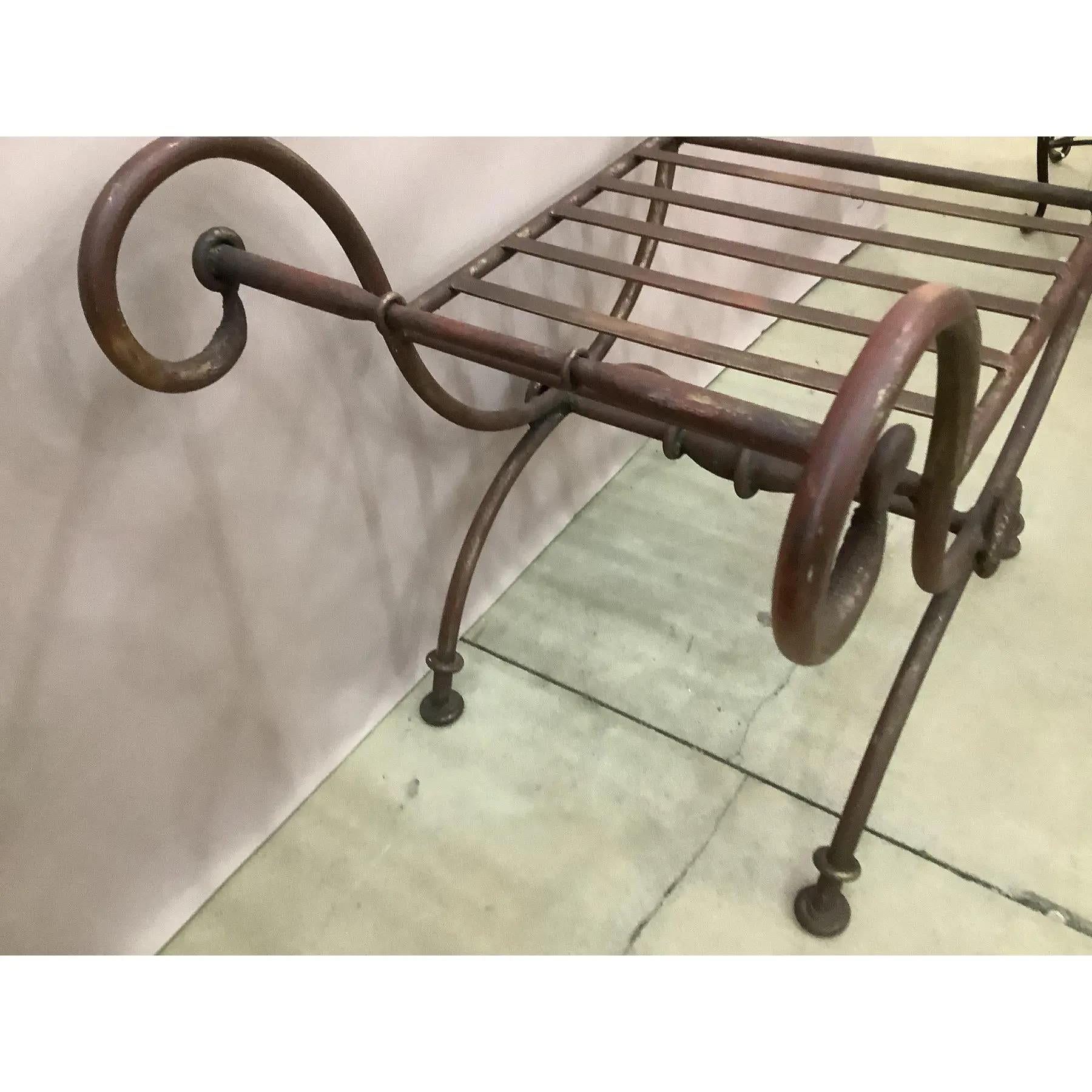 Banc vintage en fonte peint en forme de X. Avec son assise en lattes, cette pièce convient aussi bien à un cadre formel qu'à un siège d'extérieur. Le banc nécessite un coussin pour une assise plus confortable.