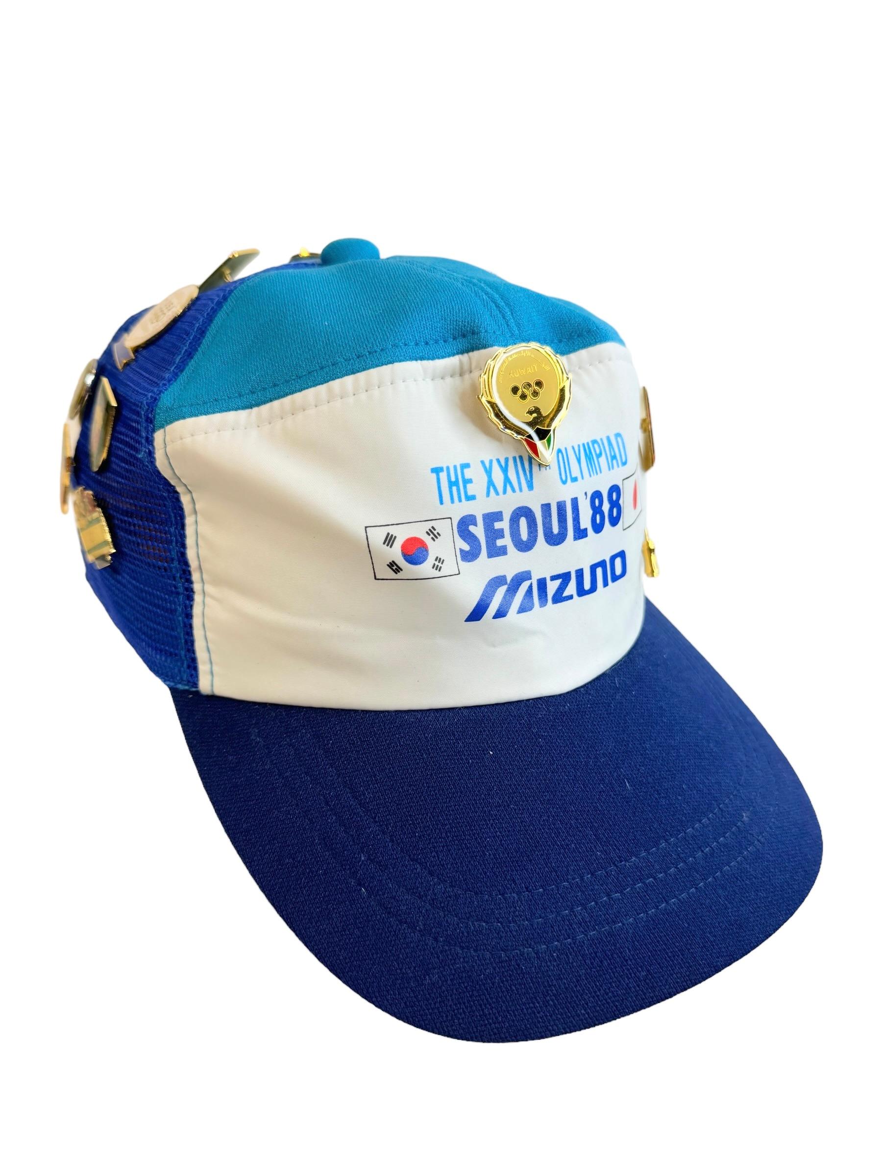 Original südkoreanische CAP für die 24. Olympischen Sommerspiele (Spiele der XXIV. Olympiade), die 1988 in Südkorea stattfanden, mit 24 Anstecknadeln für verschiedene Länder und Sportarten.
Einige dieser Pins haben einen hohen Sammlerwert.