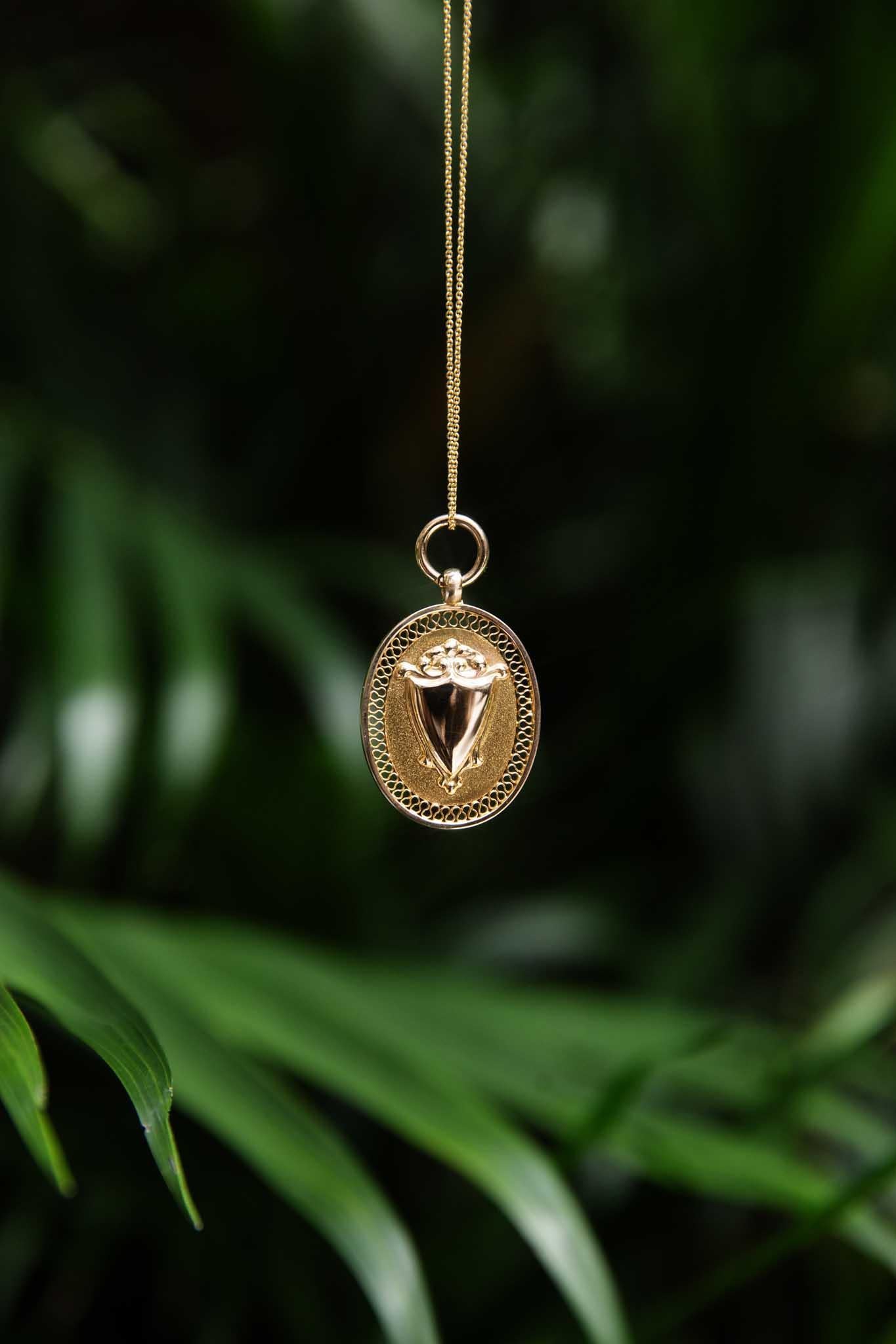 Notre pendentif Walker 1932 Oval Shield Award, en or 9 carats, témoigne d'un héritage durable. Un bouclier poli repose sur un fond texturé, encadré par un délicat travail d'ajourage. Ce pendentif est plus qu'une parure ; c'est un morceau d'histoire,