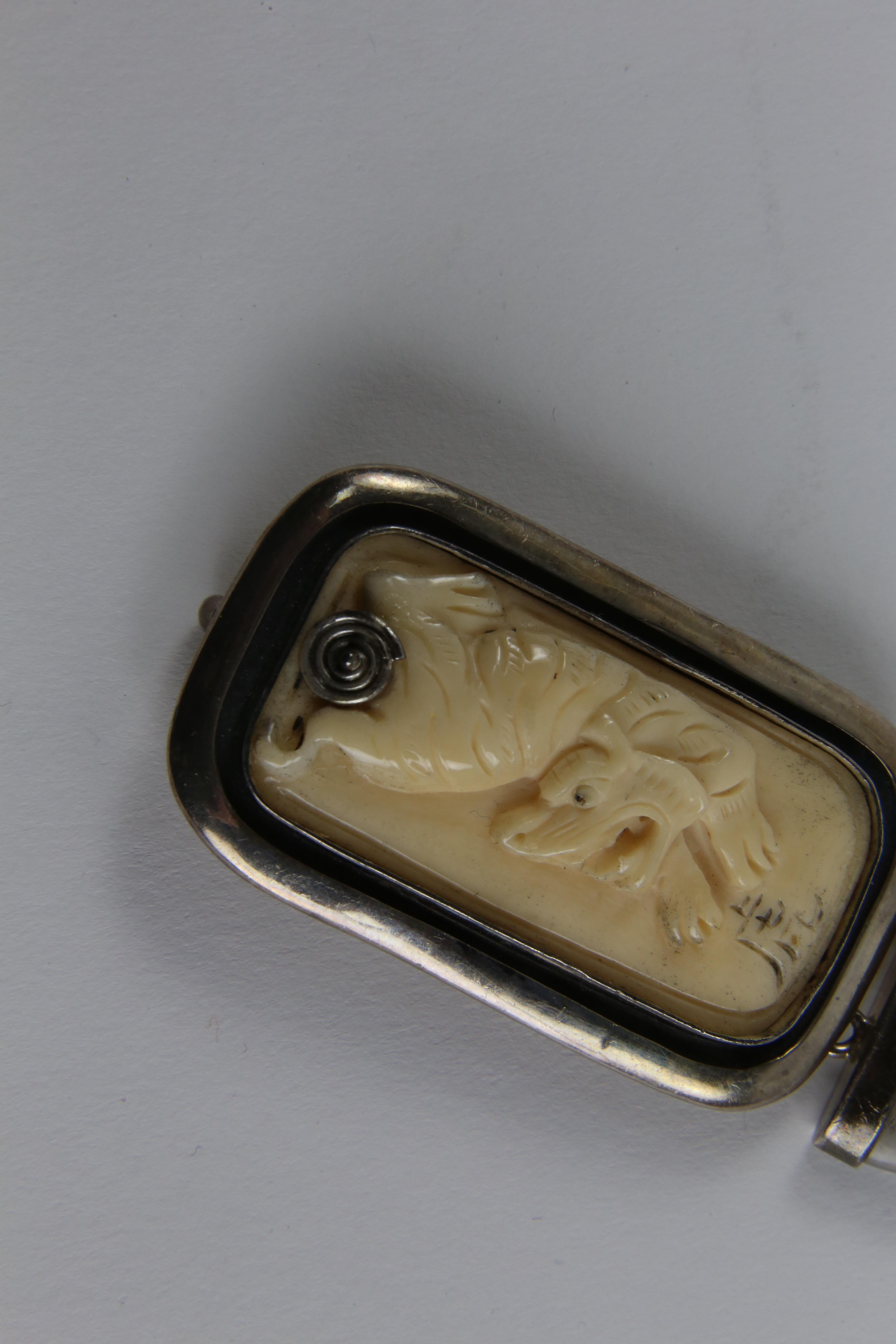 Unique Vintage Brooch Pendant depicting a Tiger encased in a Sterling Silver surround, suspending an Agate drop. Surround marked on reverse: STERLING and on reverse of bone: TIGER 1938. 1950. 1962. 1974. 1986. Approx. size: 3.5” long x 1 3/8” wide.