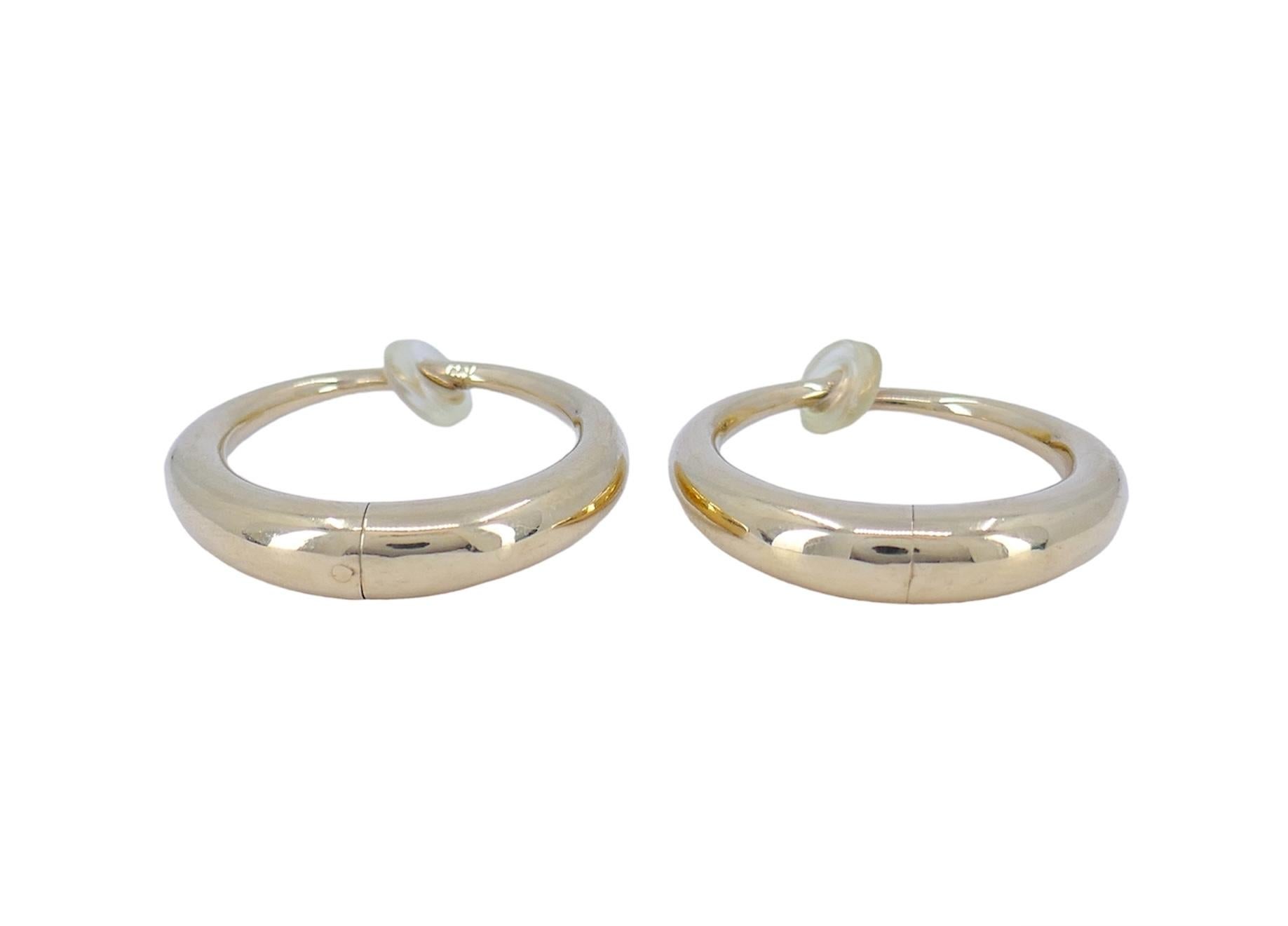 Crafted in the the 1990s, these vintage 14k gold hoop earrings exude elegance. With a weight of 8.9 grams, and a classic hoop design, these earrings boast a length and width of 1.13 inches, making them both statement-making and versatile. Designed