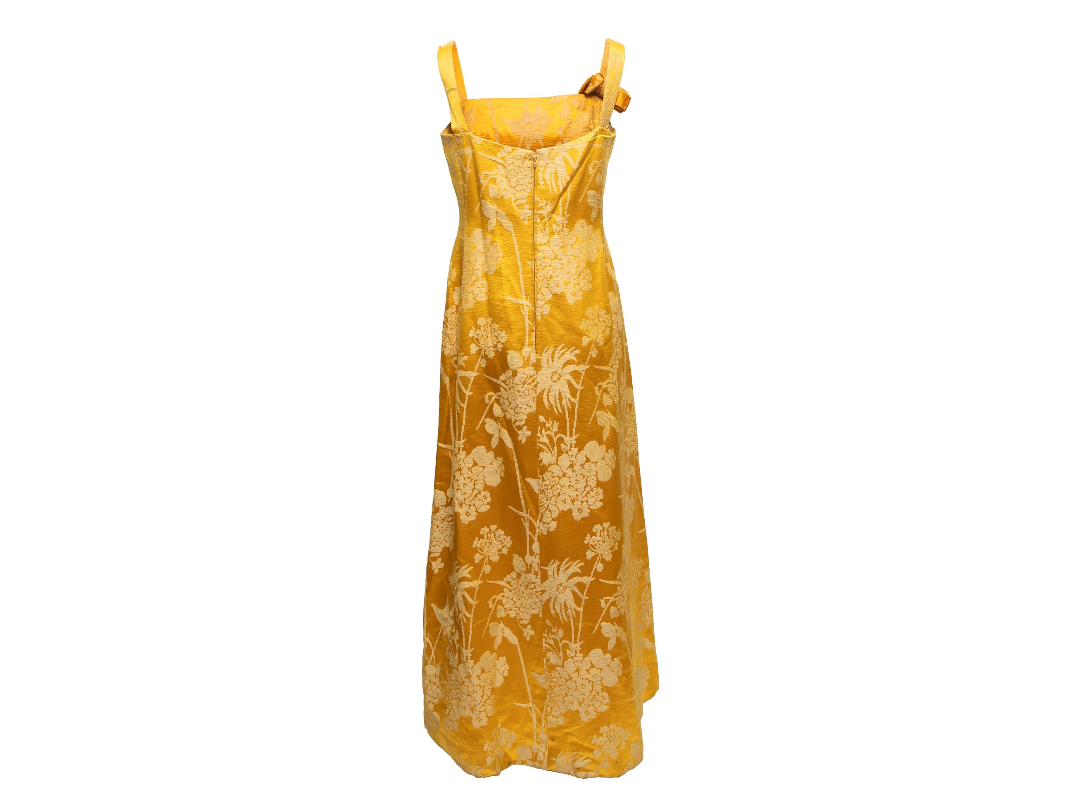 Vintage yellow floral jacquard sleeveless gown by Branell. Square neckline. Narrow straps featuring bow accent. Zip closure at center back. 32