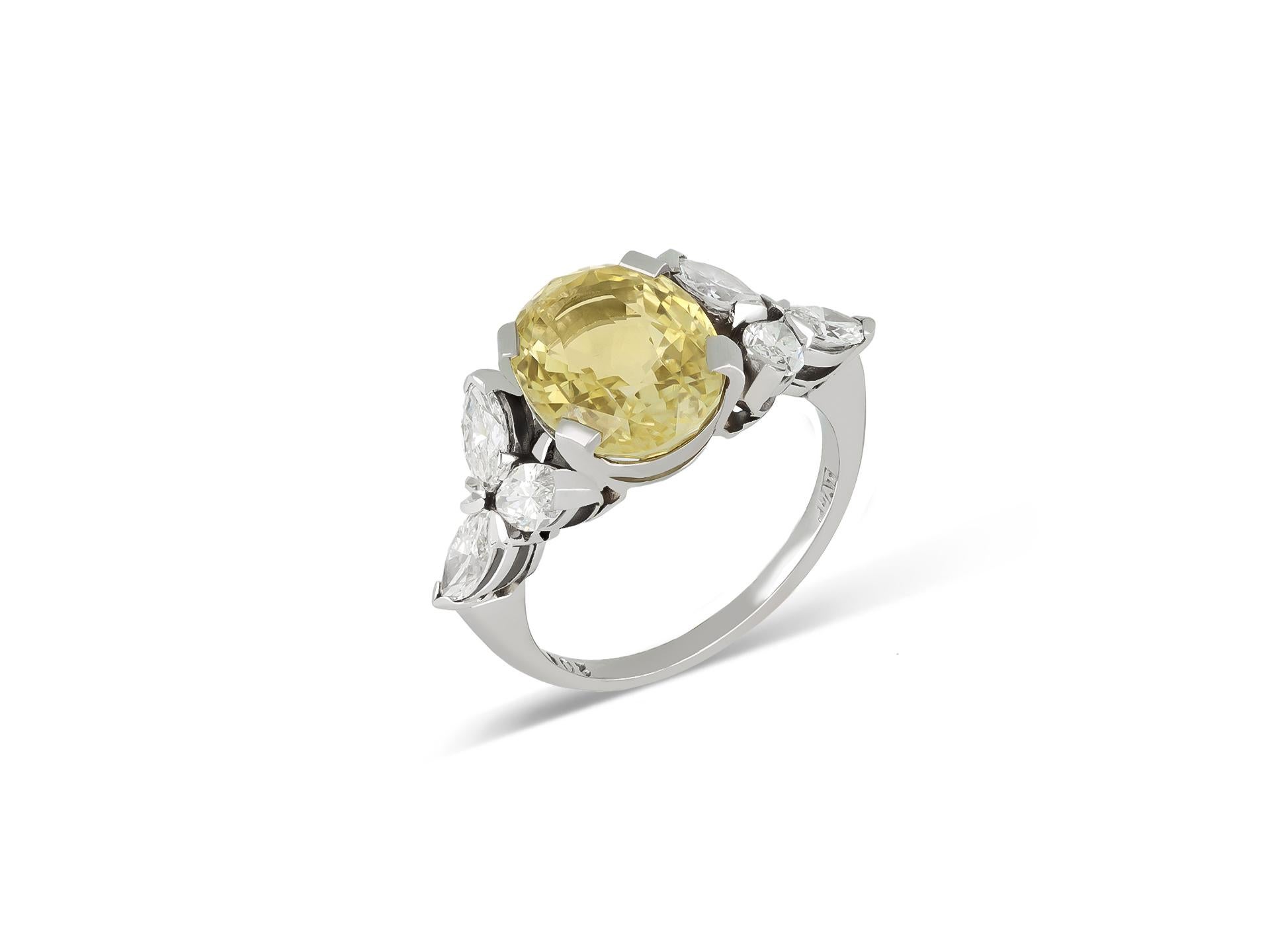Vintage yellow Ceylon sapphire and diamond ring. Centrally set with an oval old cut natural unenhanced yellow Ceylon sapphire in an open back claw setting with an approximate weight of 6.03 carats, flanked by six marquise shape brilliant cut