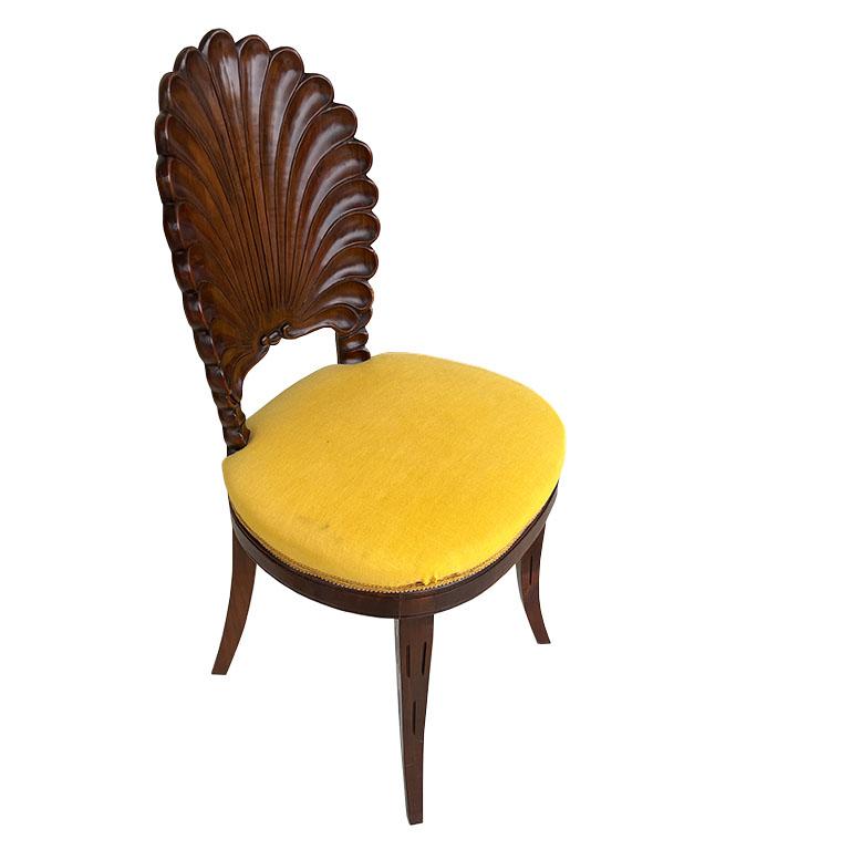 An exquisitely carved wood Venetian shell back chair. This gorgeous piece is carved of rich dark wood. The back resembles a Venetian Grotto shell. It has splayed legs with lines carved down the front of the two front chairs. It is upholstered in a