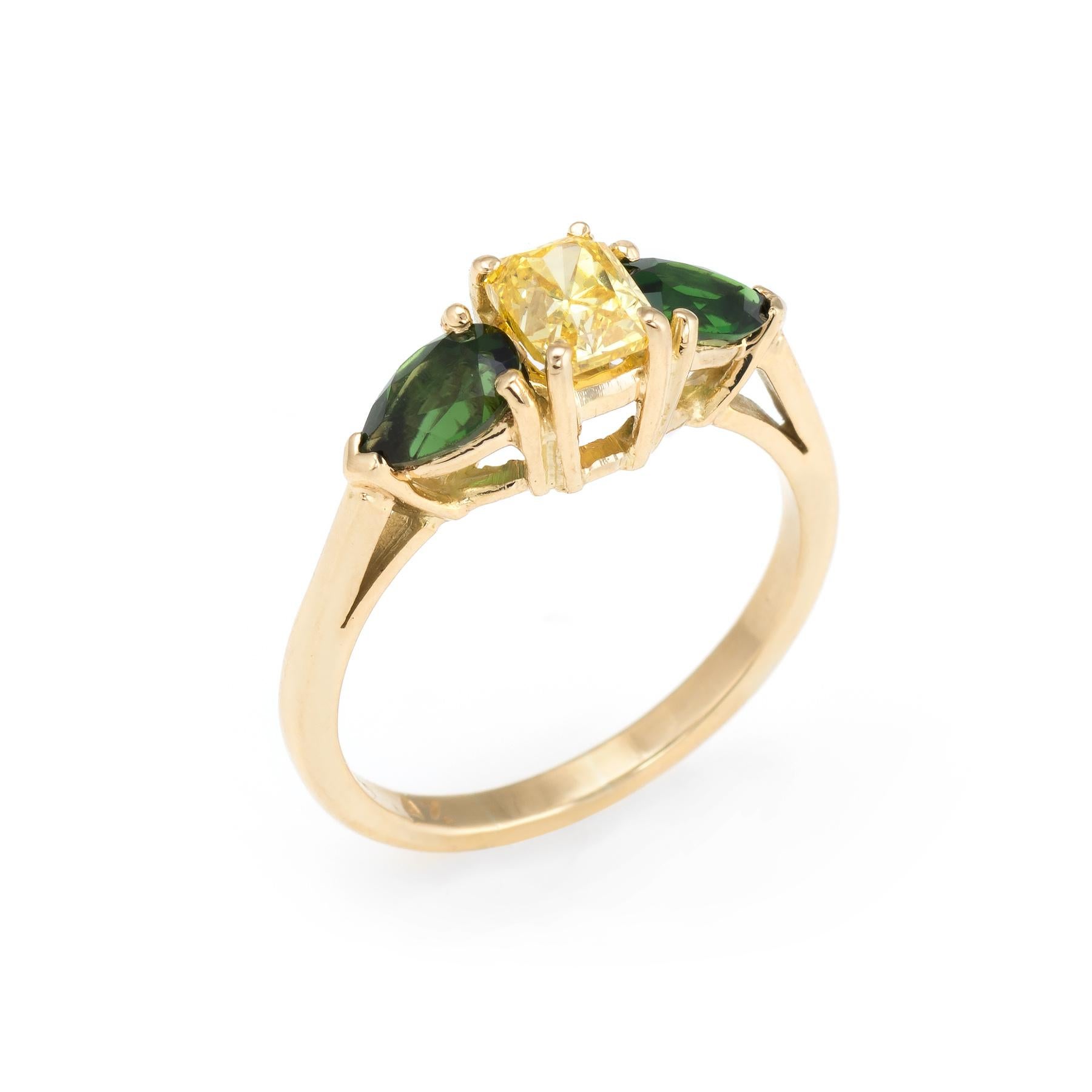 Finely detailed vintage three stone yellow diamond & green tourmaline ring, crafted in 18 karat yellow gold. 

One radiant cut diamond, approx. 0.70ct (5.22 x 4.03 x 3.51mm), fancy vivid yellow color (due to treatment), VS-2 clarity, good cut.

Two